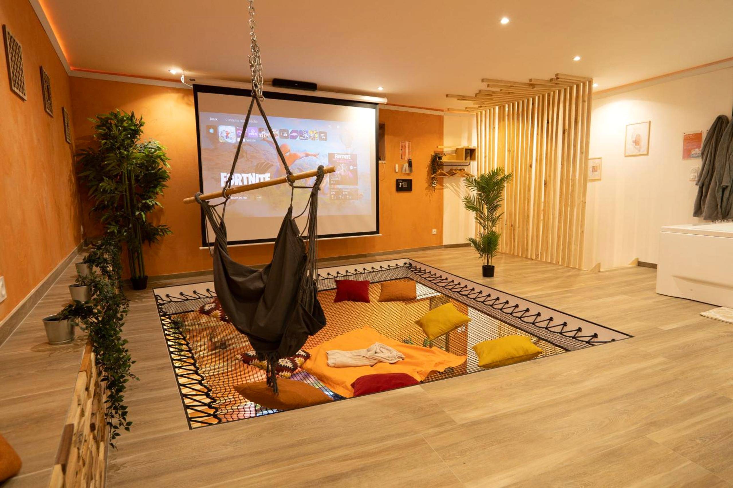 Filet de détente suspendu face au home cinéma - Capsule Marrakech I Chicha I Sauna I Balnéo I Console PS5 I Cinéma