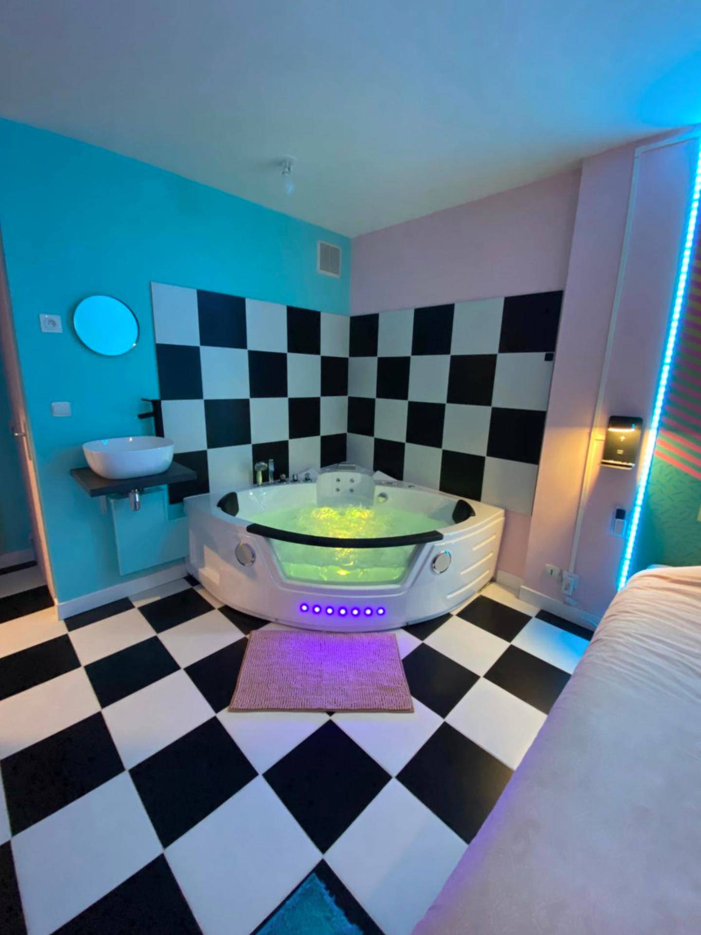 Baignoire balnéo devant un mur en damier - Capsule Miami Vice - Jacuzzi - Billard - Ecran cinéma & Netflix - Ping - Pong...