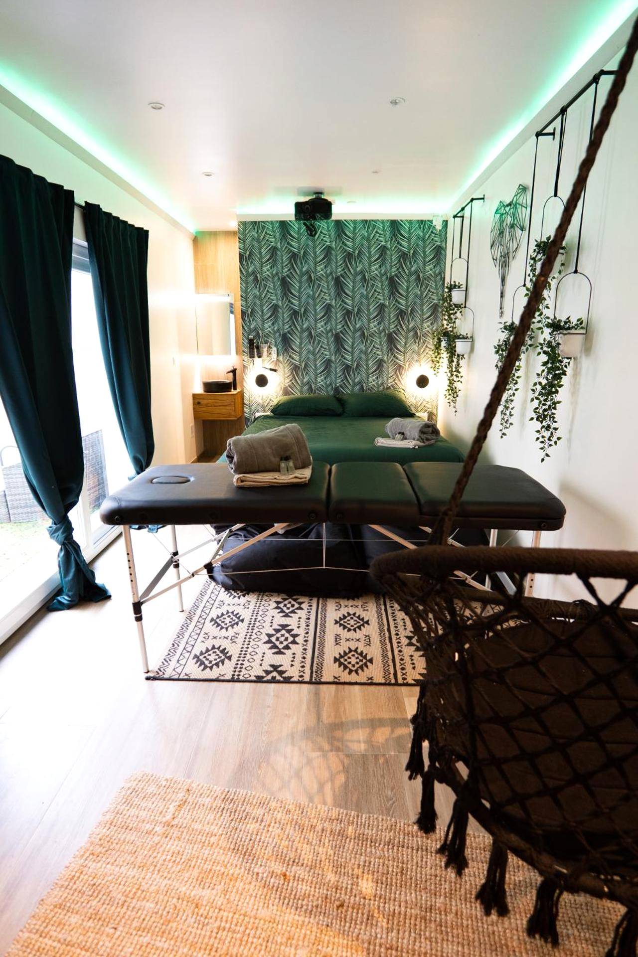 Table de massage face au lit king size - Capsule Thailande I Sauna I Balnéo I Console I jeux en bois I Cinéma I cour...
