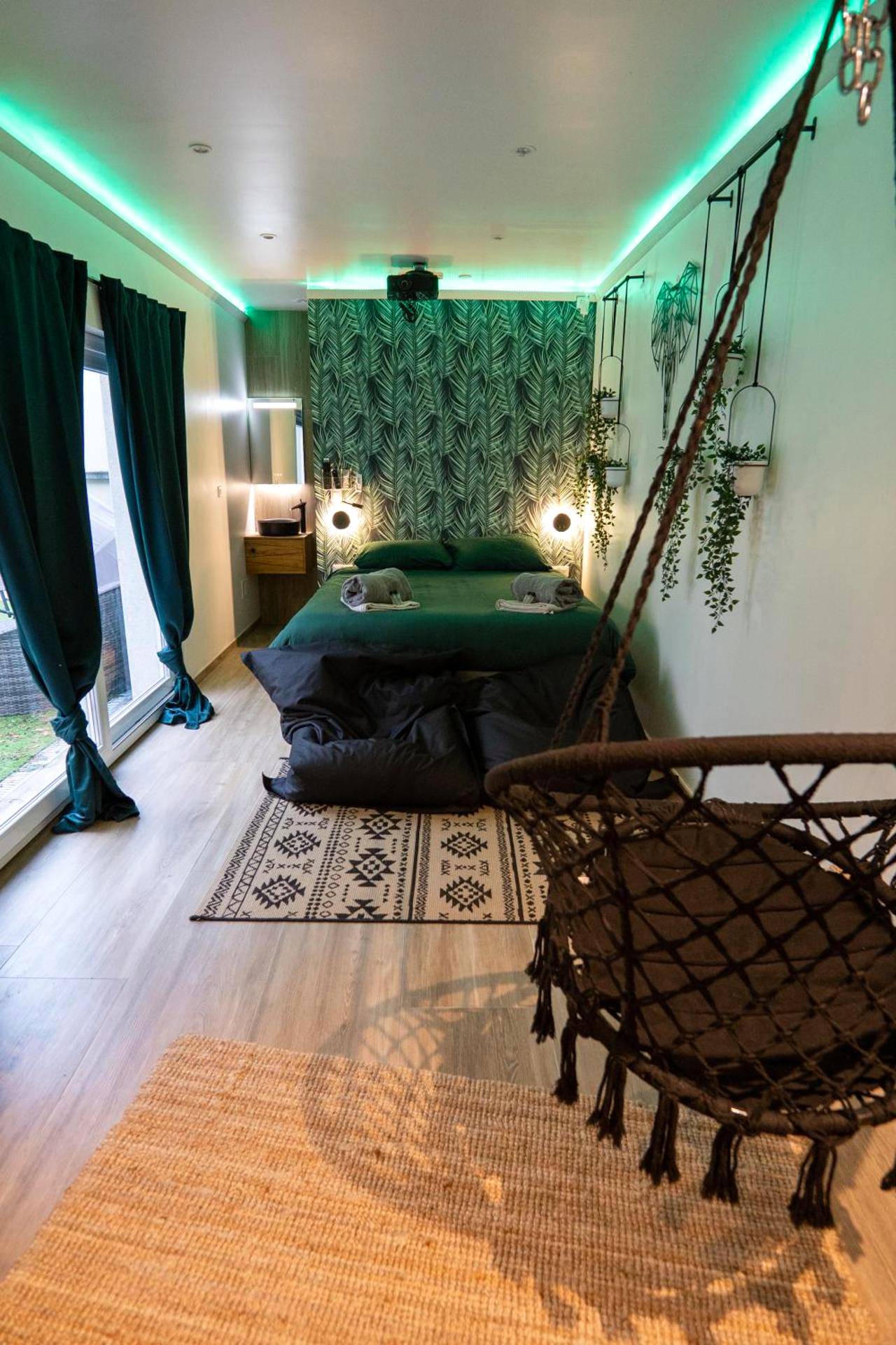 Chambre avec fauteuil suspendu et néons verts - Capsule Thailande I Sauna I Balnéo I Console I jeux en bois I Cinéma I...