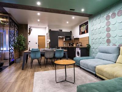 Salon moderne avec canapé d'angle coloré - Capsule Wellness - sauna - balneo - machine de sport privatif - PS5 - 2 chambres