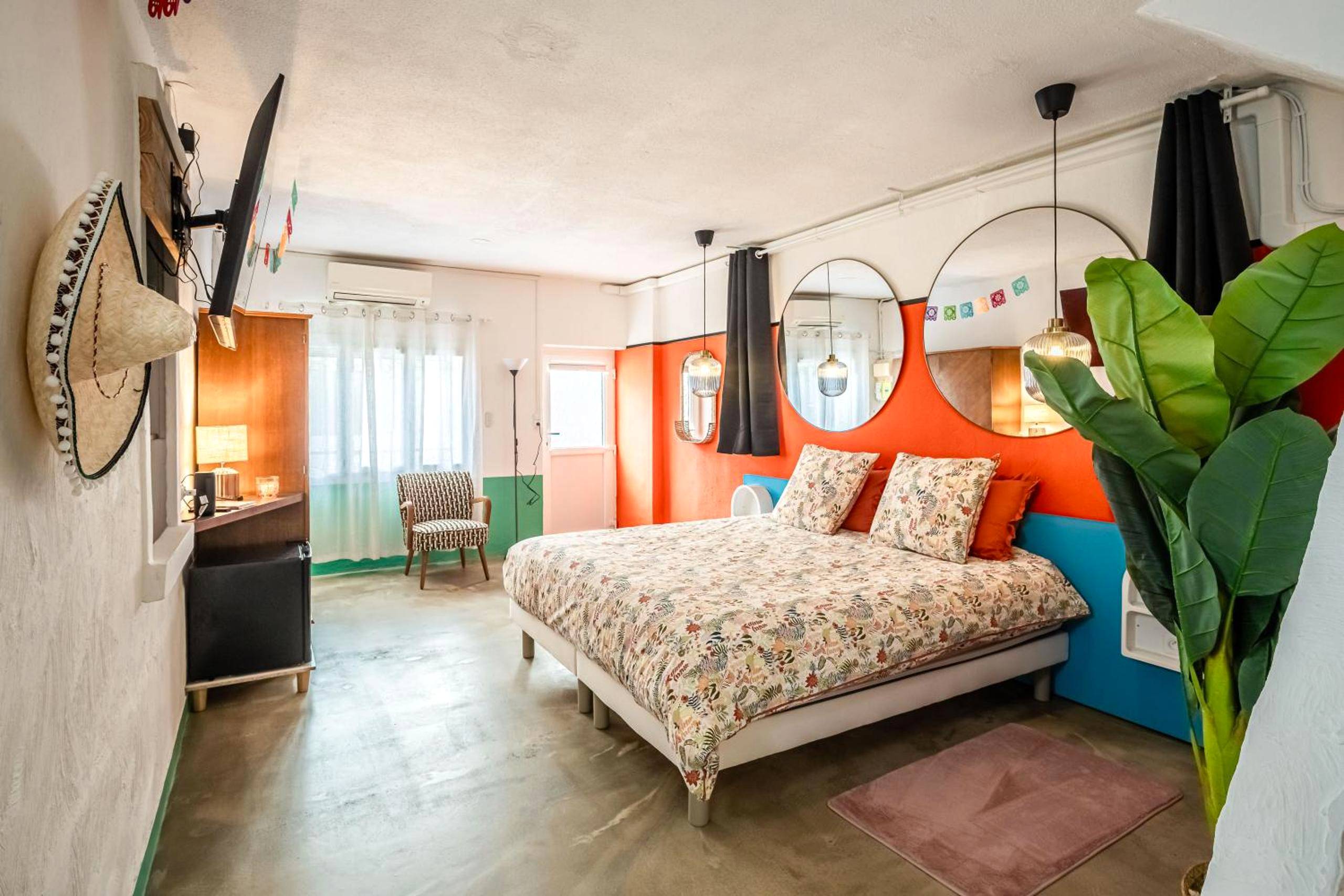 Chambre colorée avec miroirs ronds et lit double - Casa Amor Balnéo Sauna