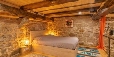 Lit double en mezzanine avec murs en pierre - Cassiopée