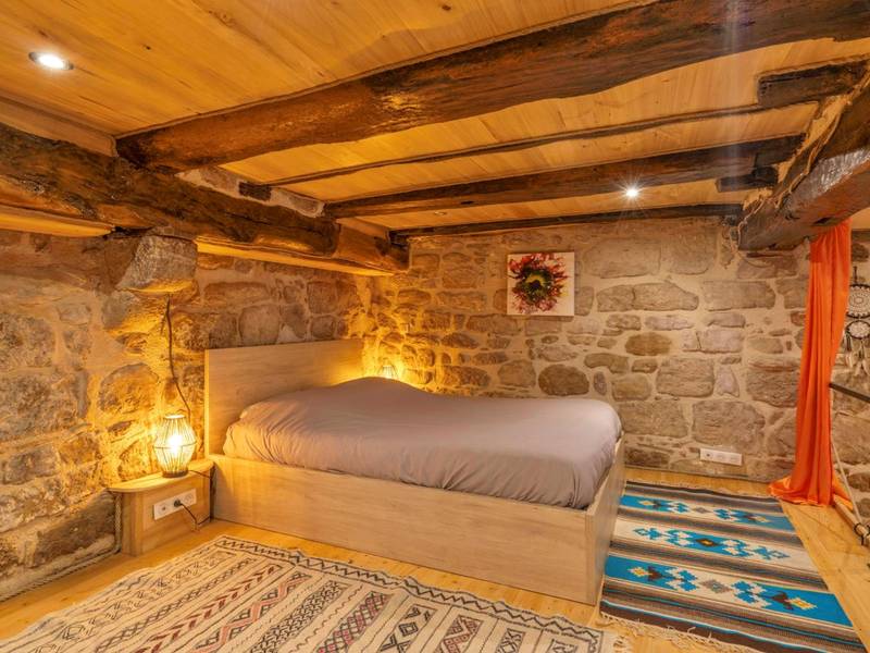 Lit double en mezzanine avec murs en pierre - Cassiopée