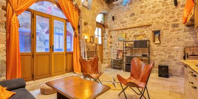 Salon avec fauteuils en cuir et rideaux orange - Cassiopée