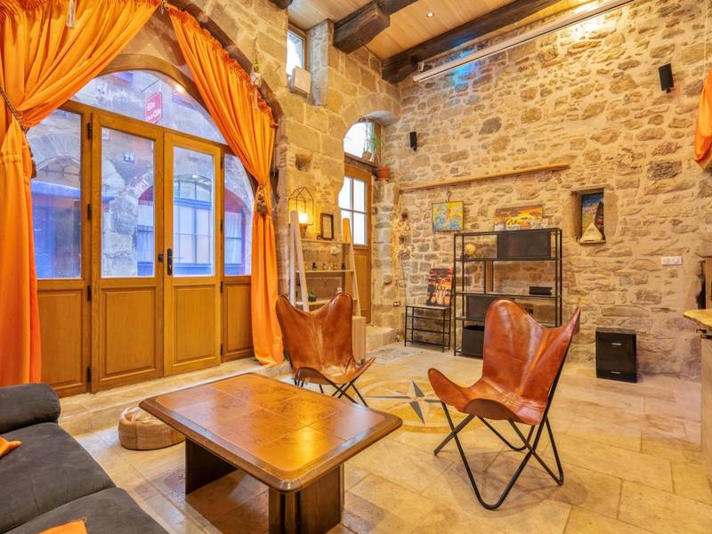 Salon avec fauteuils en cuir et rideaux orange - Cassiopée