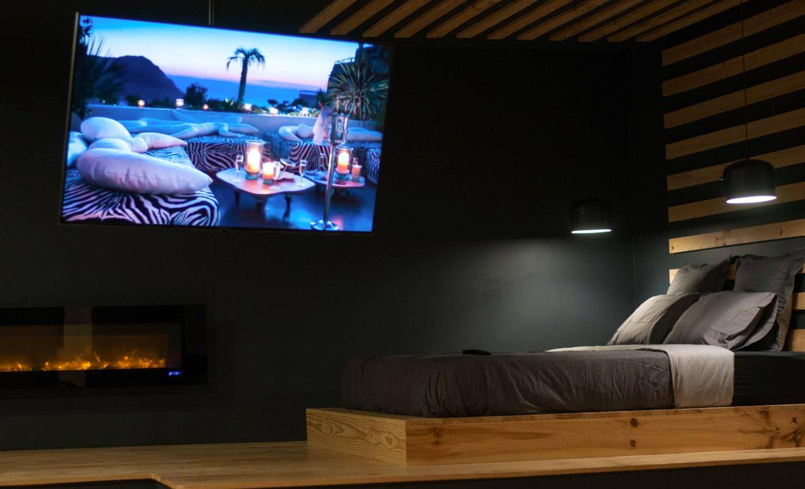 Lit sur estrade avec cheminée et grand écran - LOVEROOM METZ CATHEDRALE