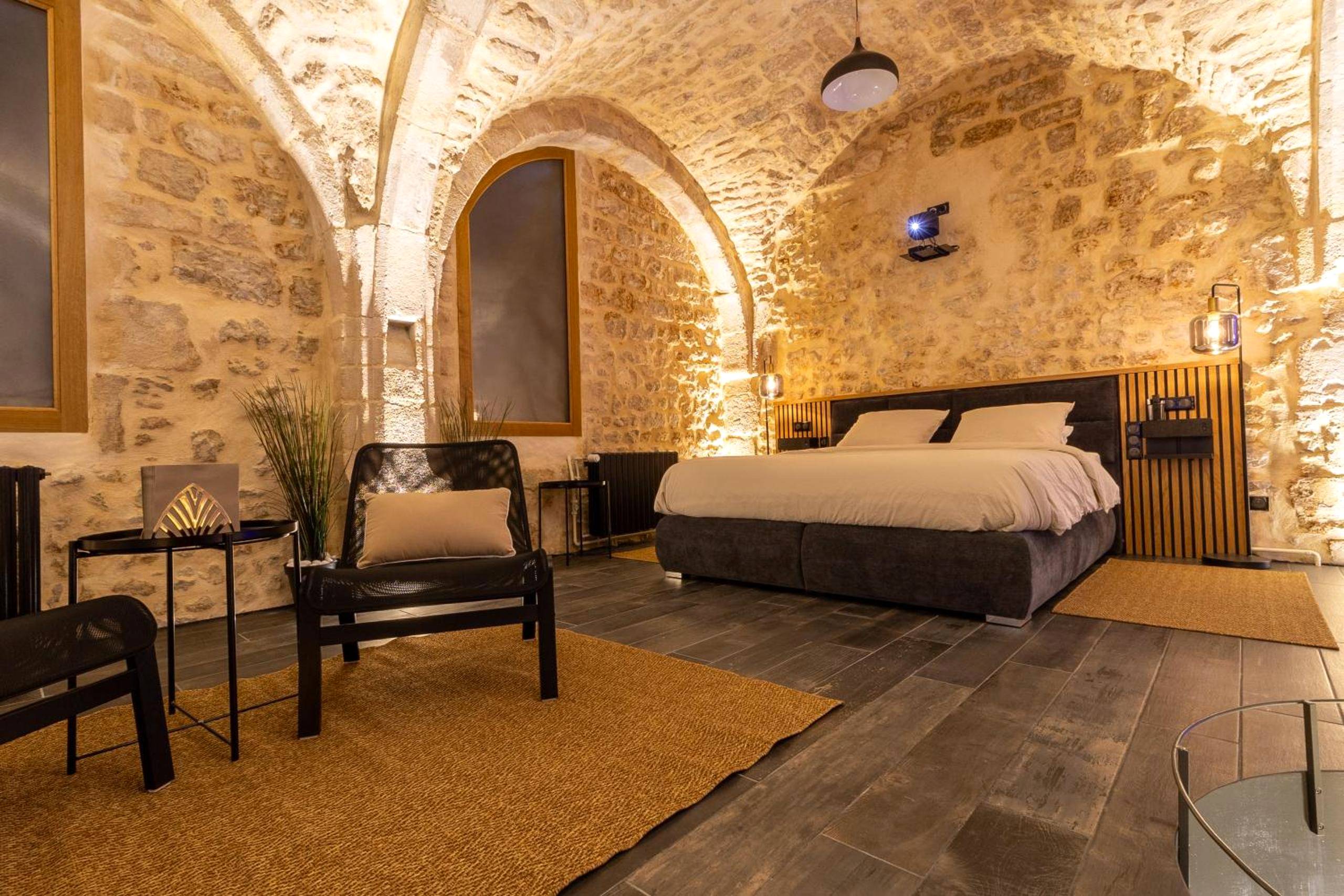 Lit king size dans chambre aux murs de pierre - Cave privatif by XELA
