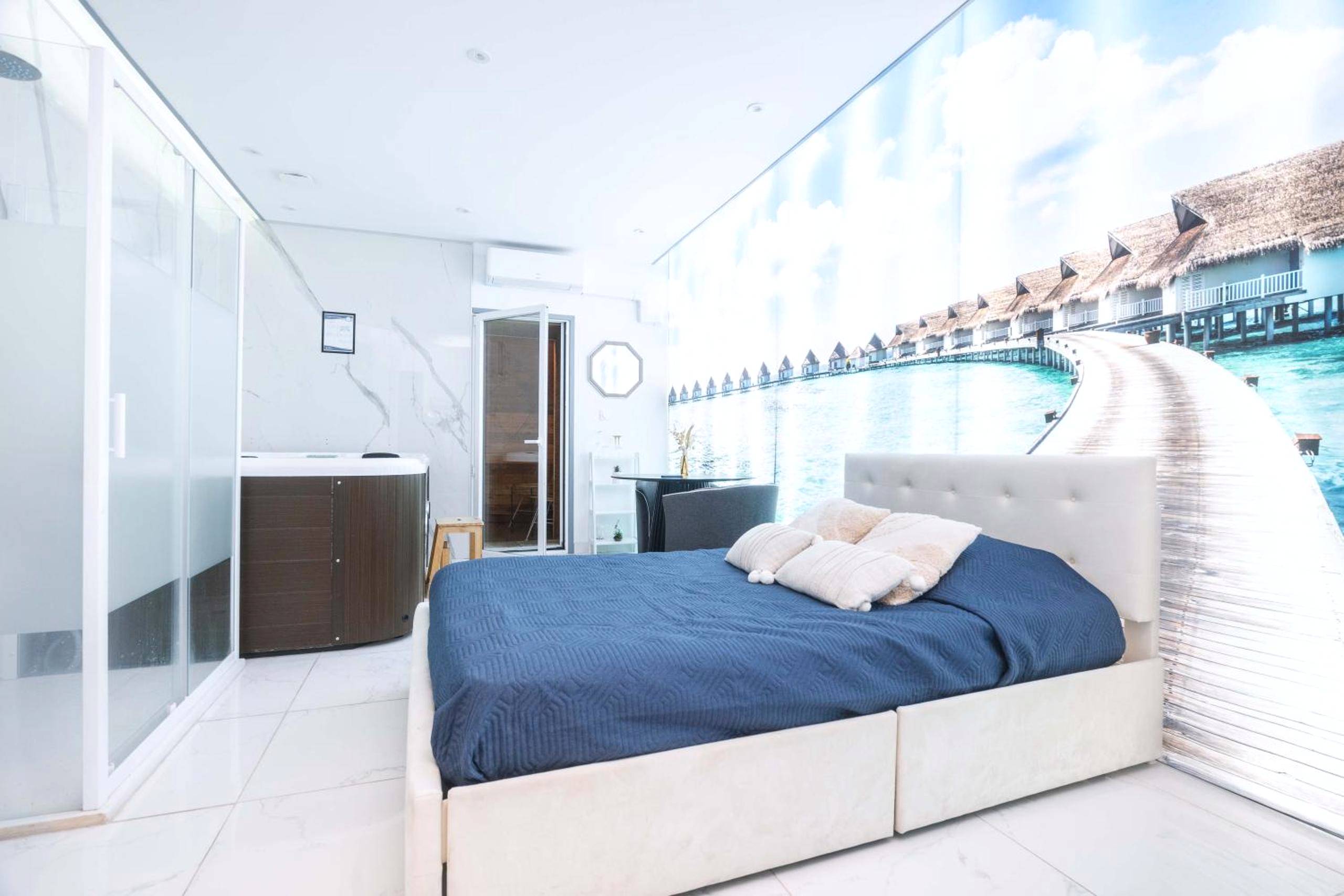 Lit double et jacuzzi face à une fresque marine - Love Room Vichy - Centara Spa vichy