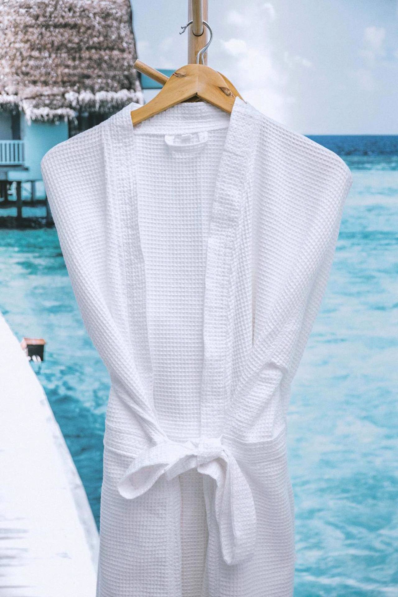 Peignoir blanc suspendu sur cintre en bois - Centara Spa vichy