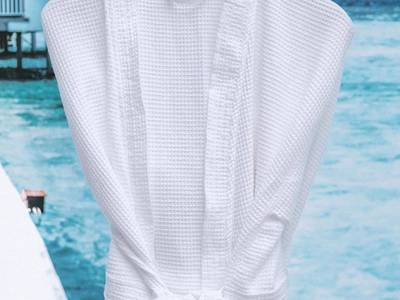 Peignoir blanc suspendu sur cintre en bois - Centara Spa vichy