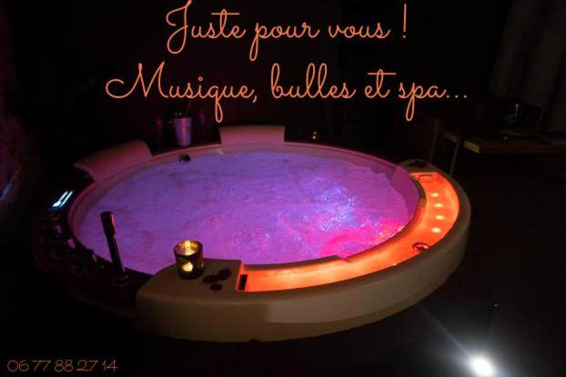 Jacuzzi rond avec éclairage rose et bougie - Love Room Médis - LOVE Suites & SPA "Le Chai" avec lit rond