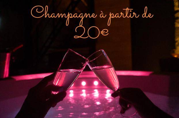 Flûtes de champagne devant un jacuzzi rose - LOVE Suites & SPA "Le Chai" avec lit rond
