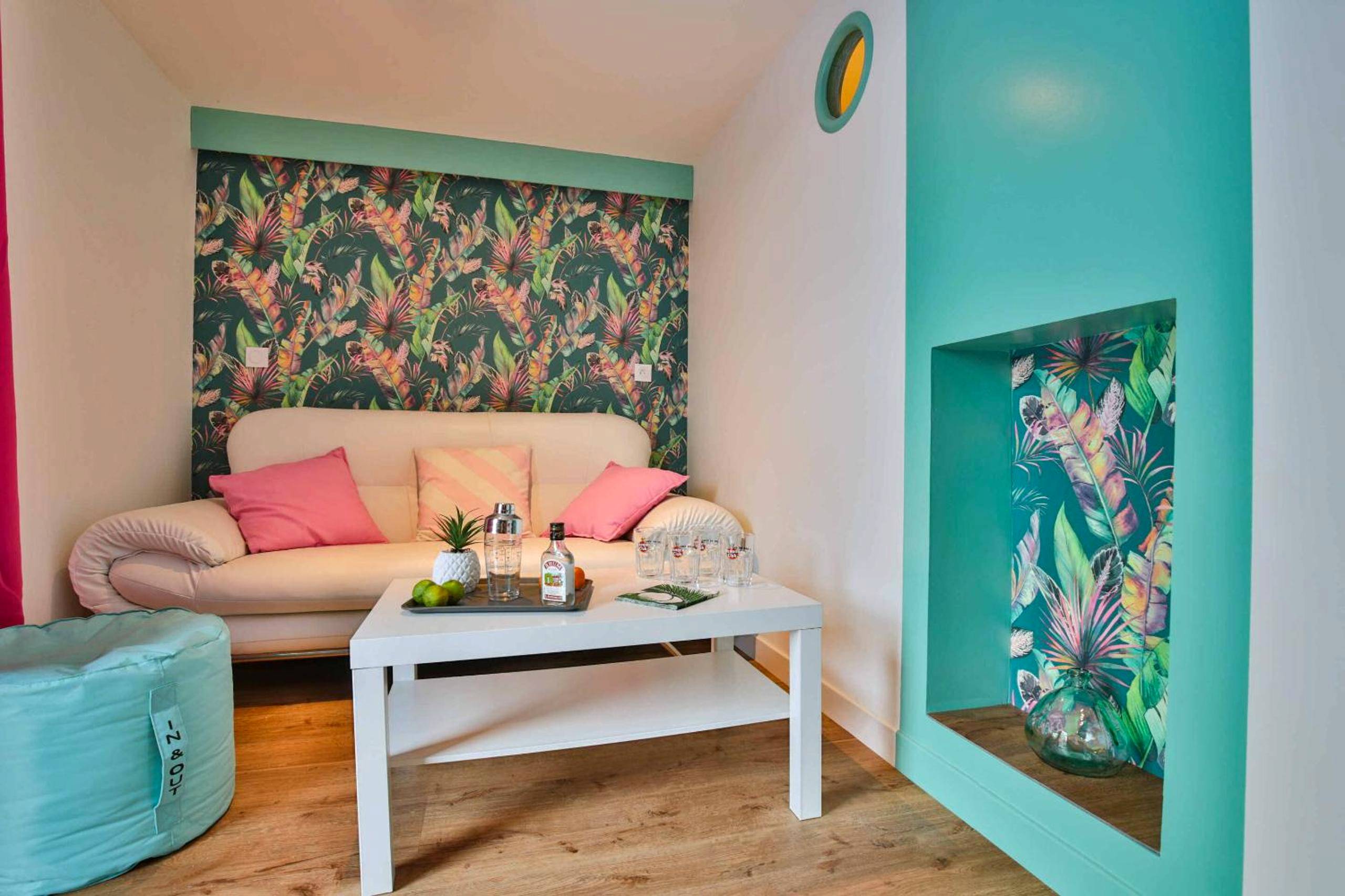 Salon avec canapé blanc et papier peint tropical - CHALET CARAIBES SPA Privatif