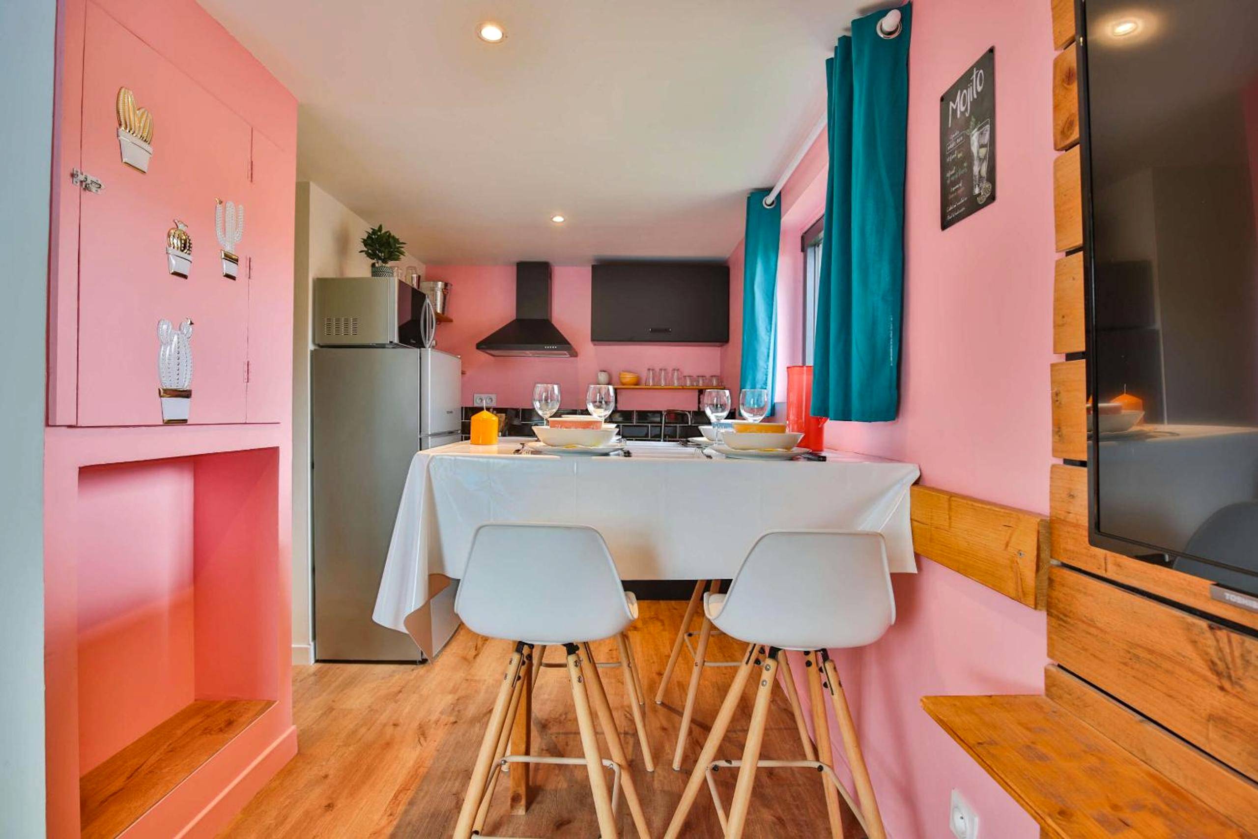 Espace repas et cuisine aux murs roses - CHALET CARAIBES SPA Privatif