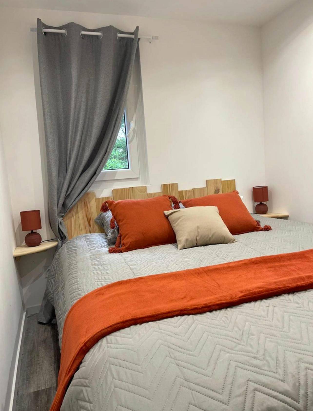 Lit double avec coussins et jeté de lit orange - Charmant chalet cocooning avec Jacuzzi