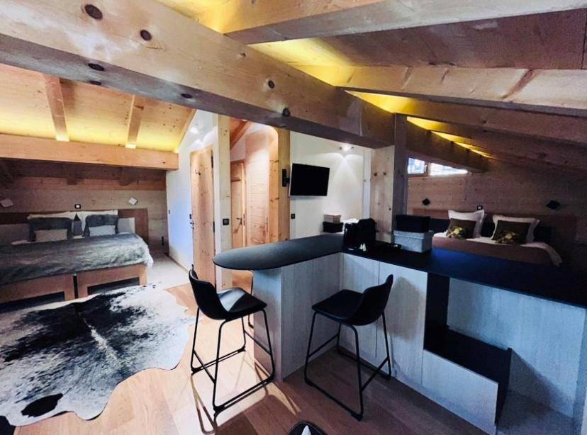 Espace de vie ouvert avec bar et deux lits - Chalet Inarpa - Appartements et Suites