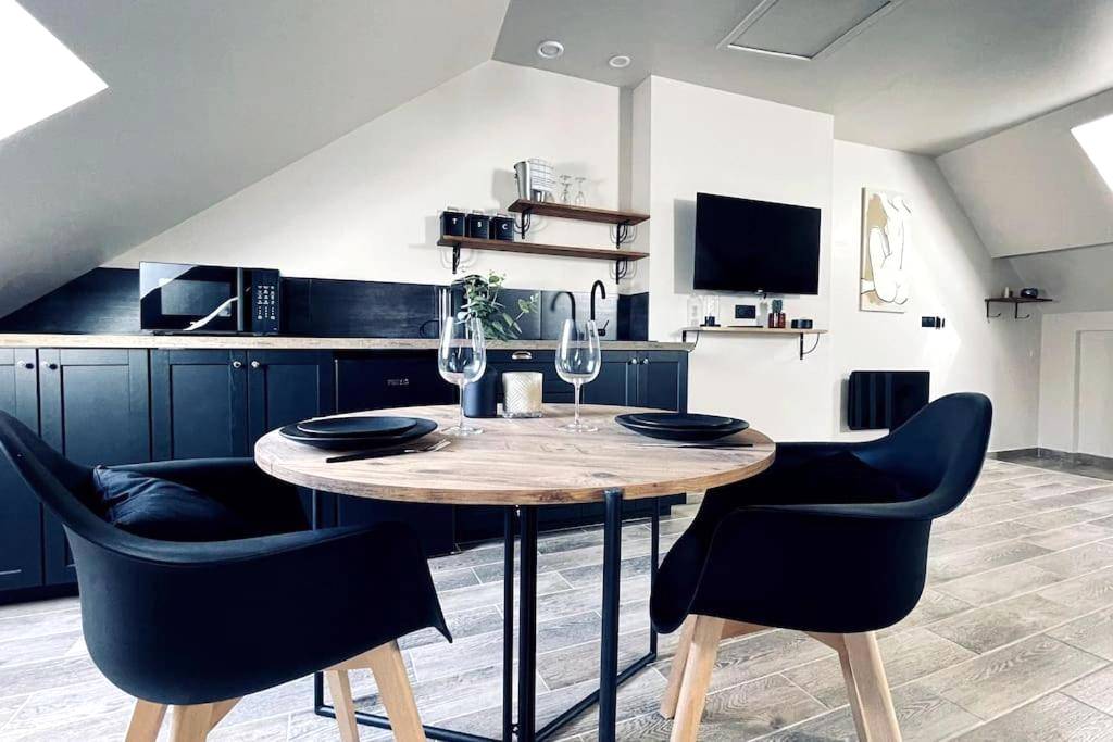 Espace repas moderne avec table ronde et TV - Love Room Le Chalet / Jacuzzi / Sauna