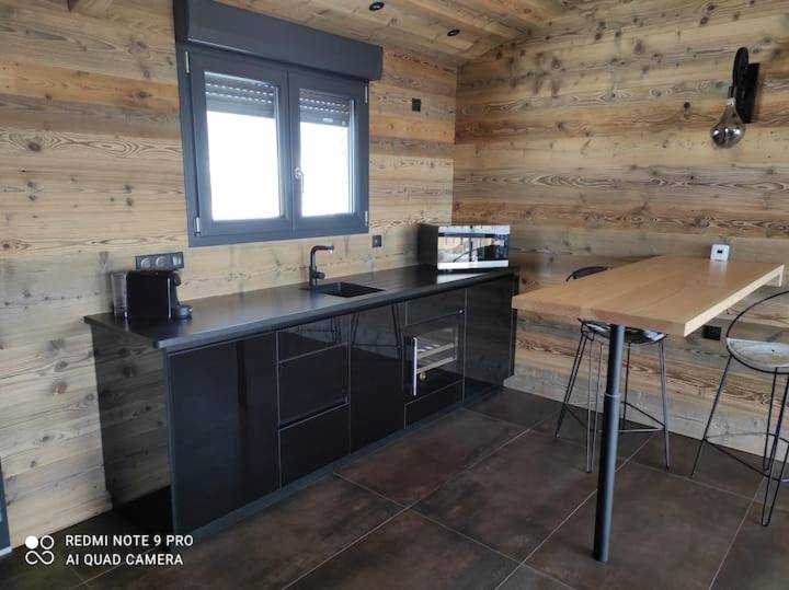 Cuisine équipée moderne et coin repas en bois - Chalet neuf avec jacuzzi privé, vue imprenable sur Massif des Vosges