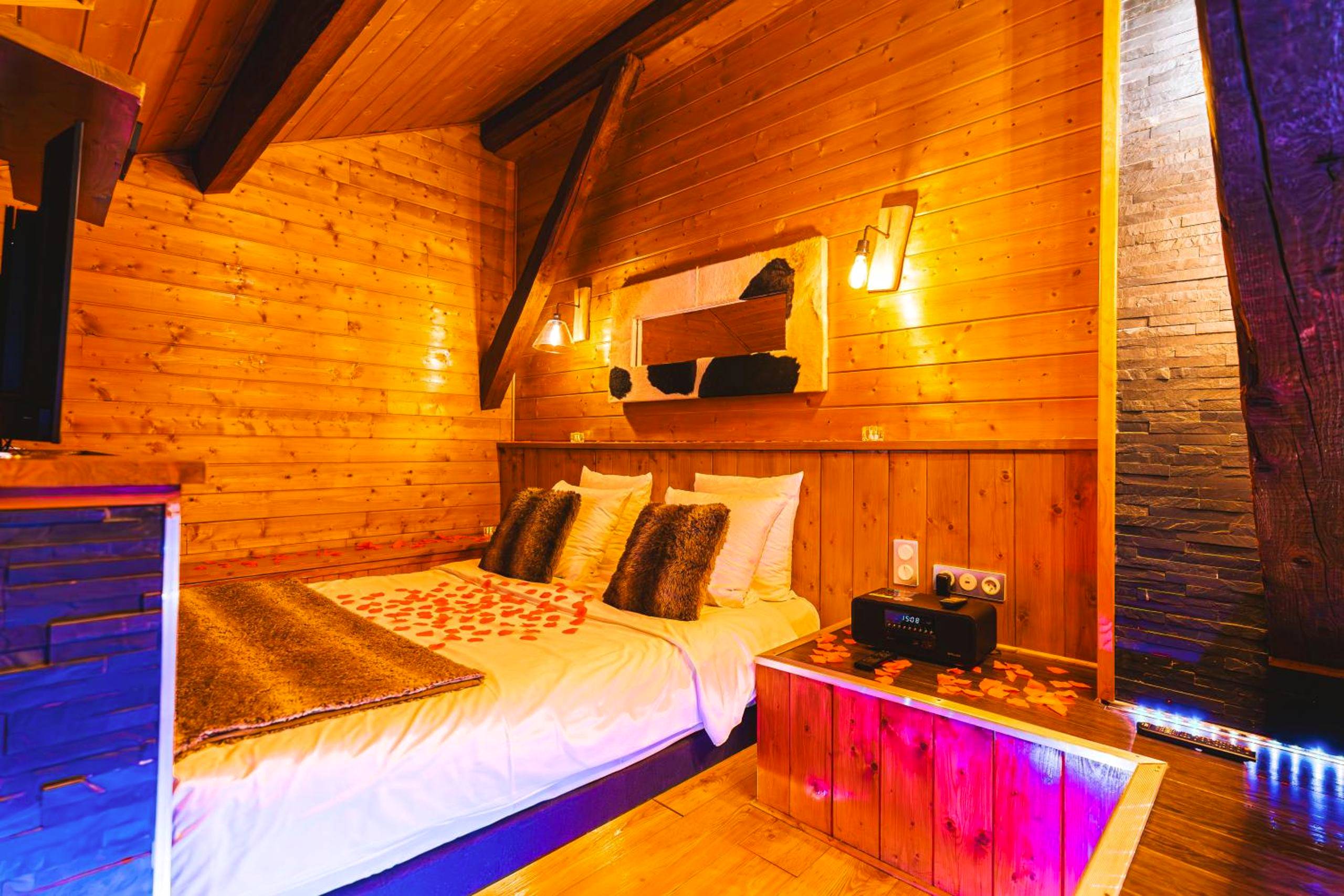 Lit double avec coussins en fourrure et pétales - Le Chalet Loft and Spa