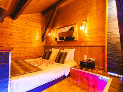 Lit double avec coussins en fourrure et pétales - Le Chalet Loft and Spa