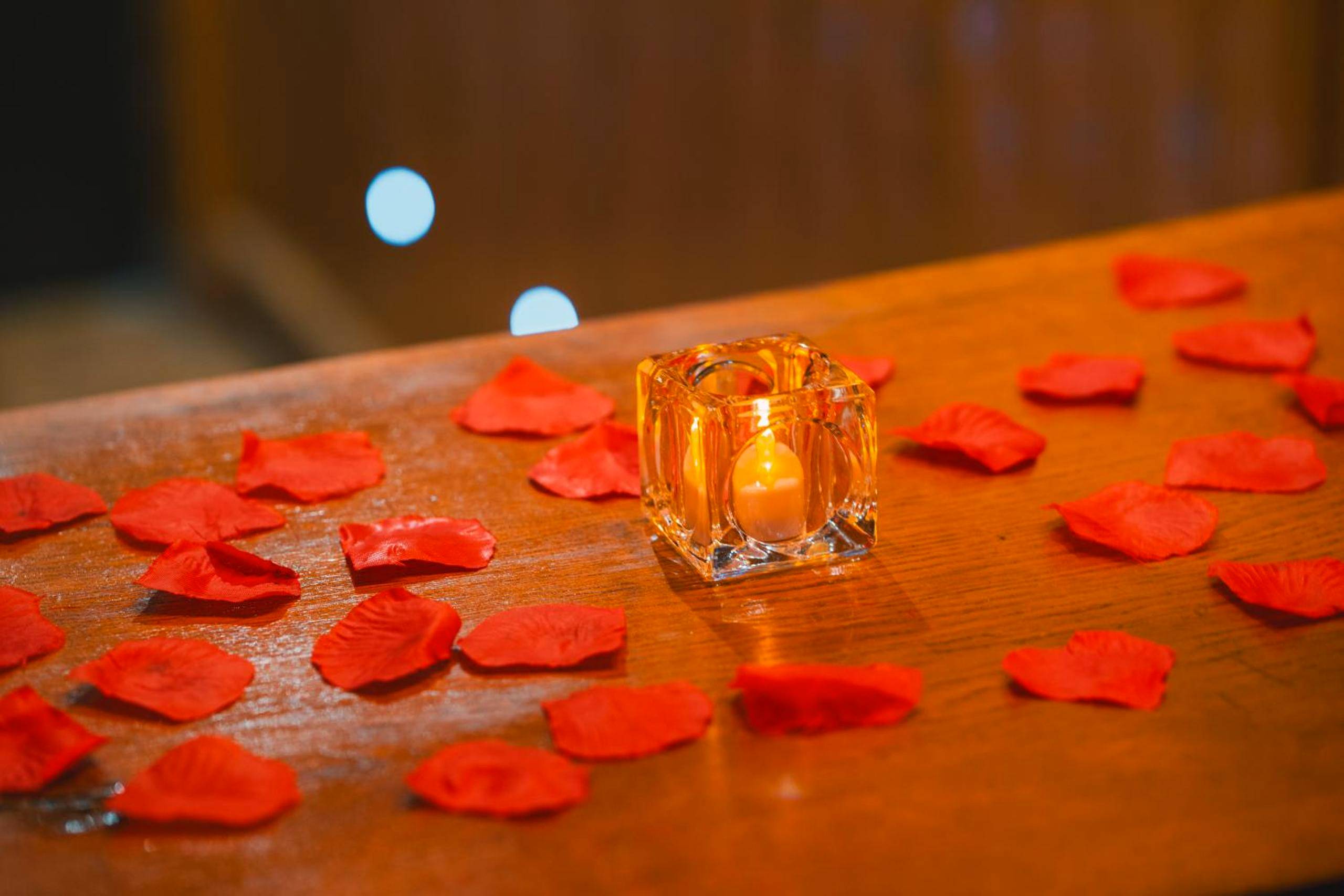 Bougie et pétales de roses sur bois - Le Chalet Loft and Spa