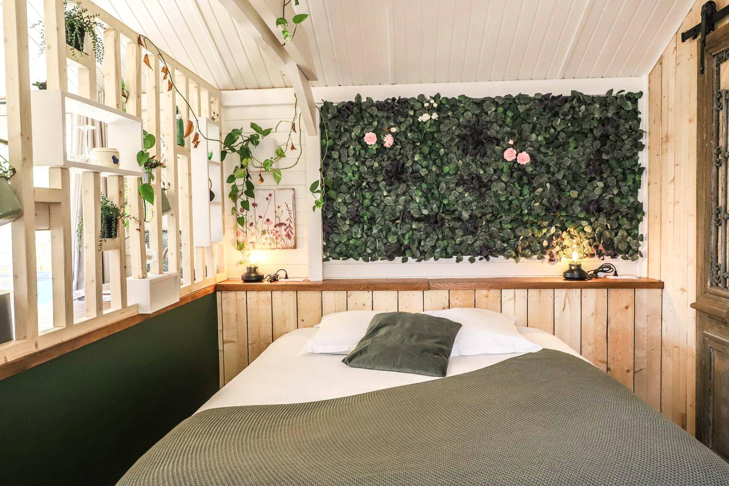 Lit double avec mur végétal et fleurs roses - Chalet Nature & Spa