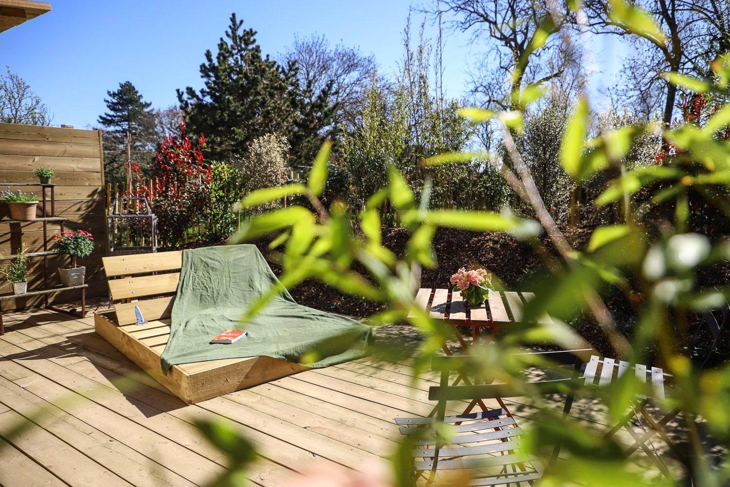 Terrasse en bois avec bain de soleil et jardin - Chalet Nature & Spa