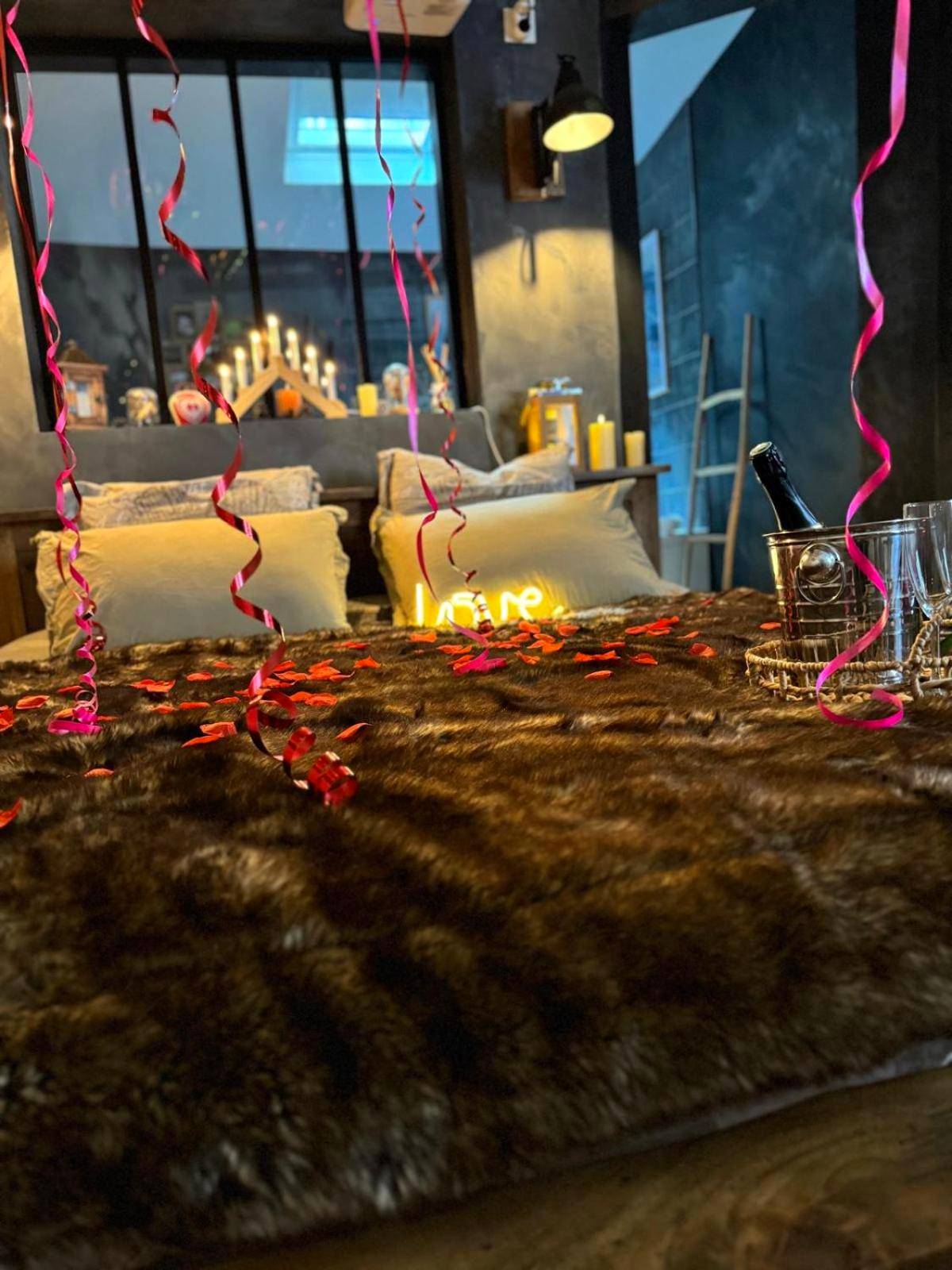 Lit avec jeté en fourrure et pétales de roses - Love Room Amiens - Le chalet romantique, SPA, Écran cinéma, Lit king...