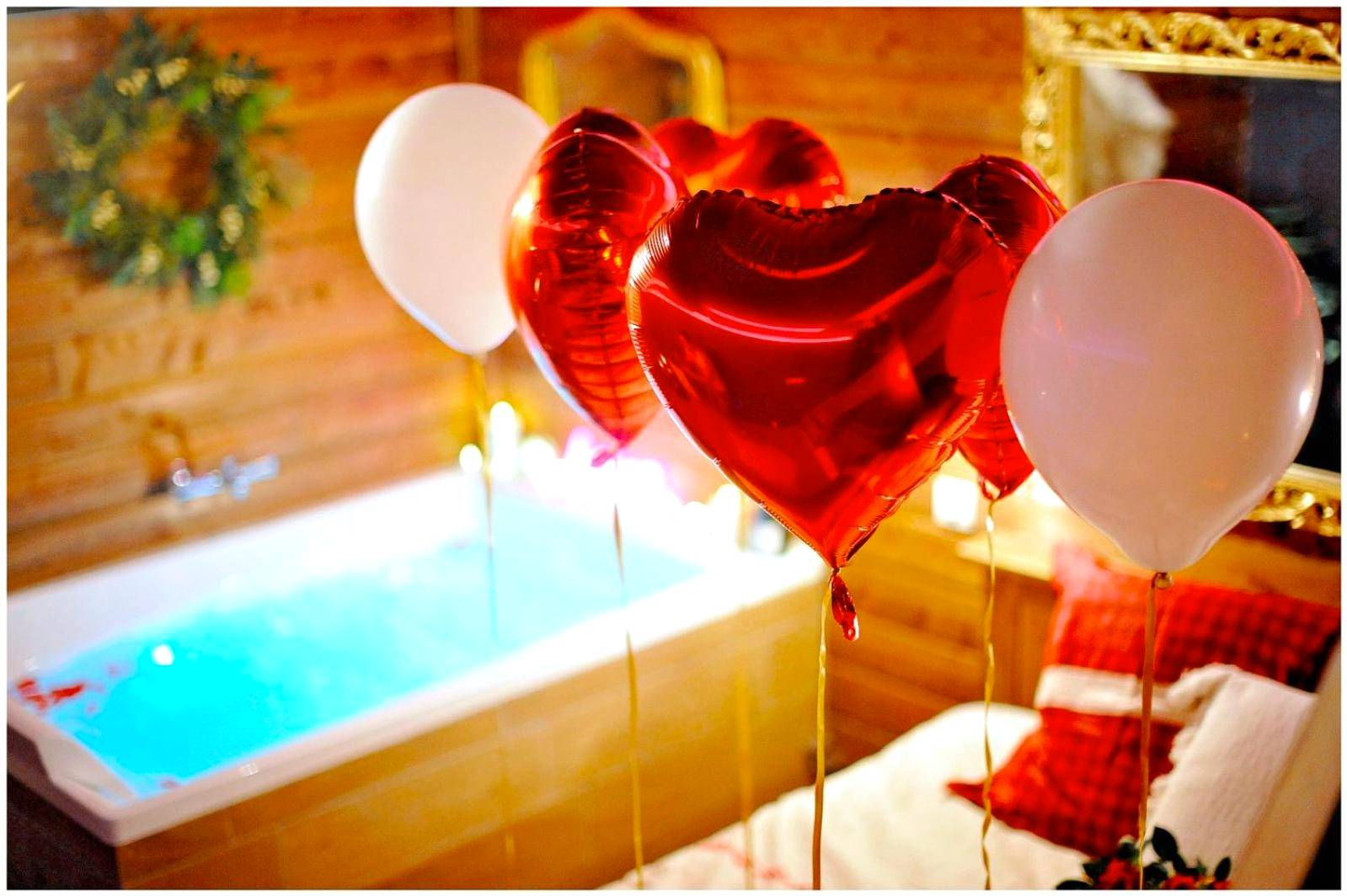 Gros plan sur ballons en cœur et jacuzzi - Le Chalet romantique, SPA XXL, Écran cinéma, Lit king size, cascade d'eau