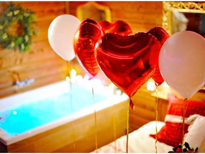 Gros plan sur ballons en cœur et jacuzzi - Le Chalet romantique, SPA XXL, Écran cinéma, Lit king size, cascade d'eau