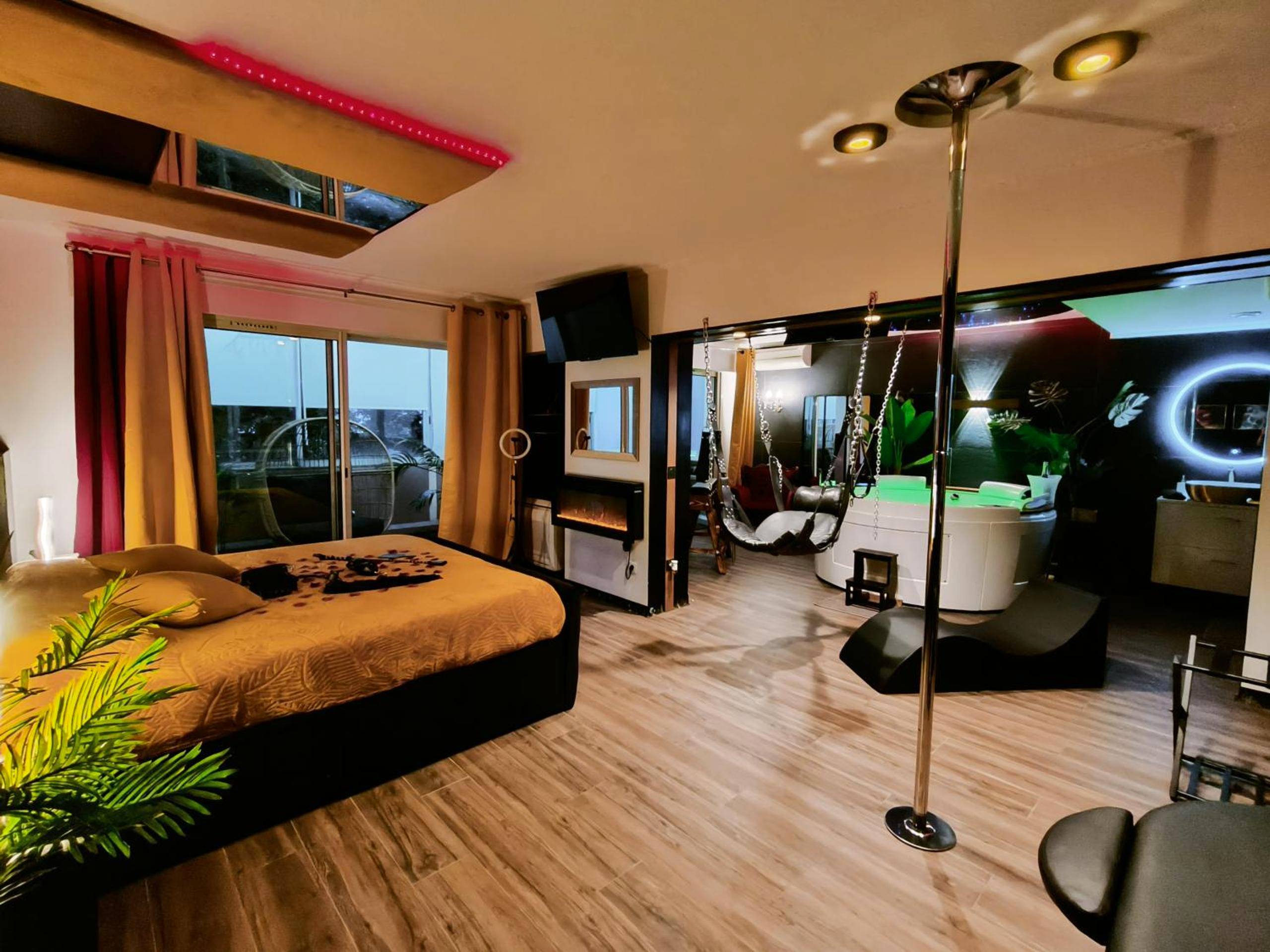 Lit king size et barre de pole dance - La loveroom bdsm de Nice " la chambre luxe des désirs "