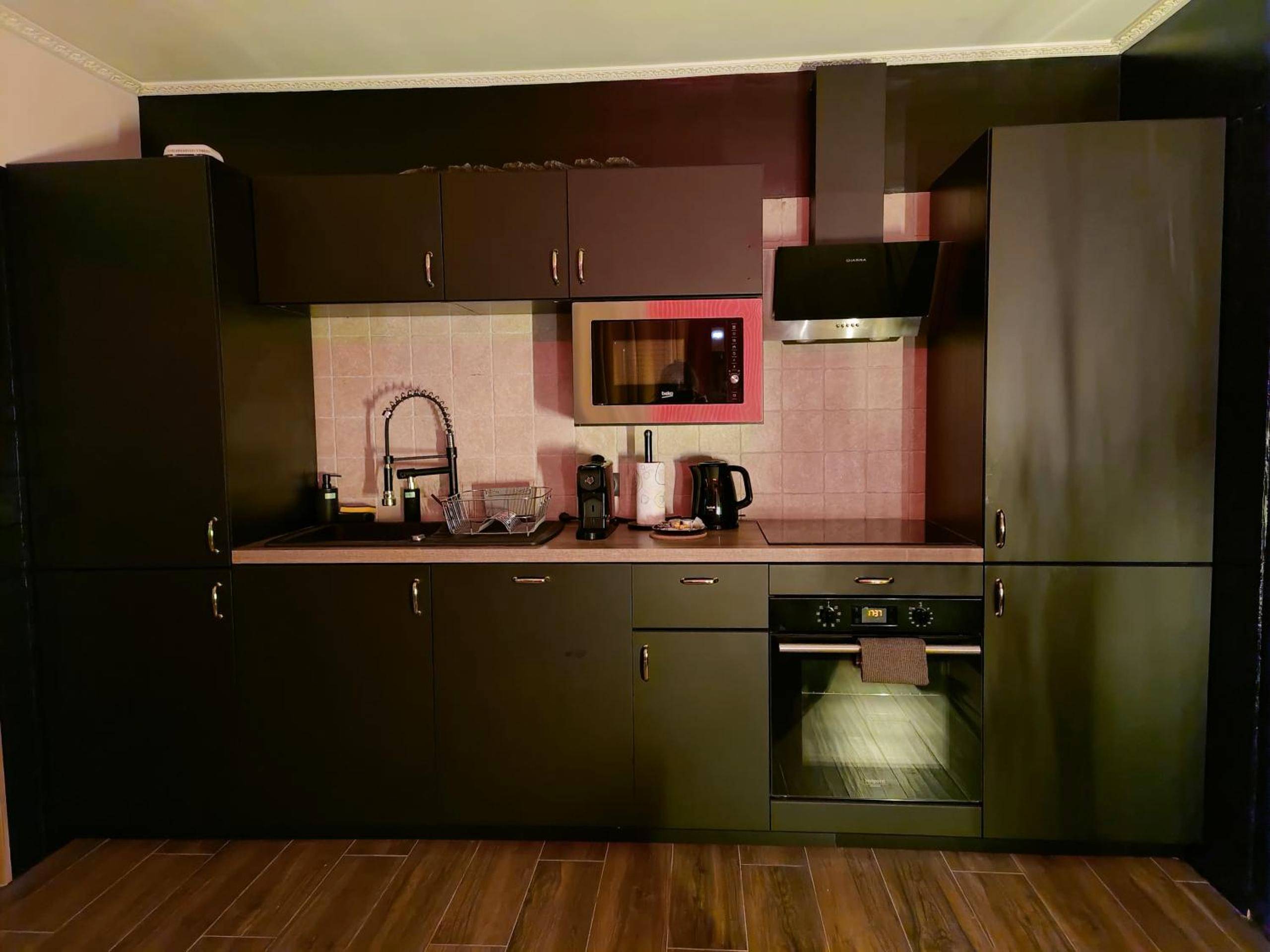 Cuisine équipée moderne aux tons sombres - La loveroom bdsm de Nice " la chambre luxe des désirs "