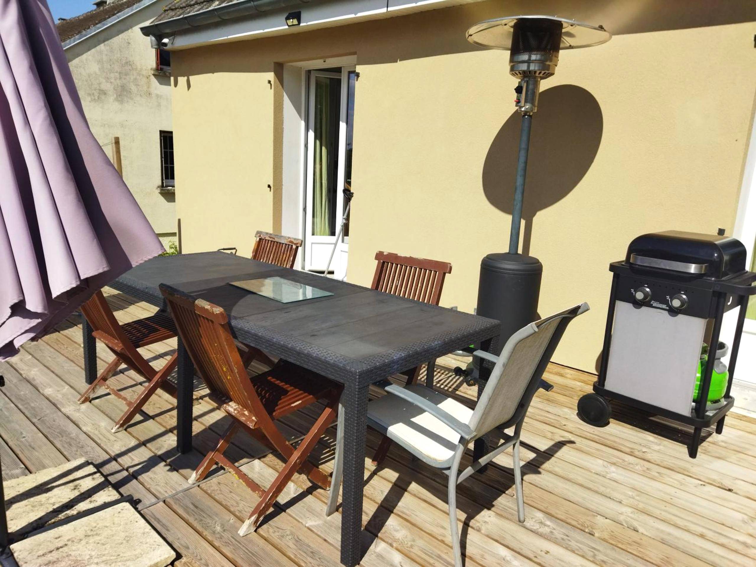Terrasse avec table, barbecue et parasol chauffant - La chambre secrète des sorciers