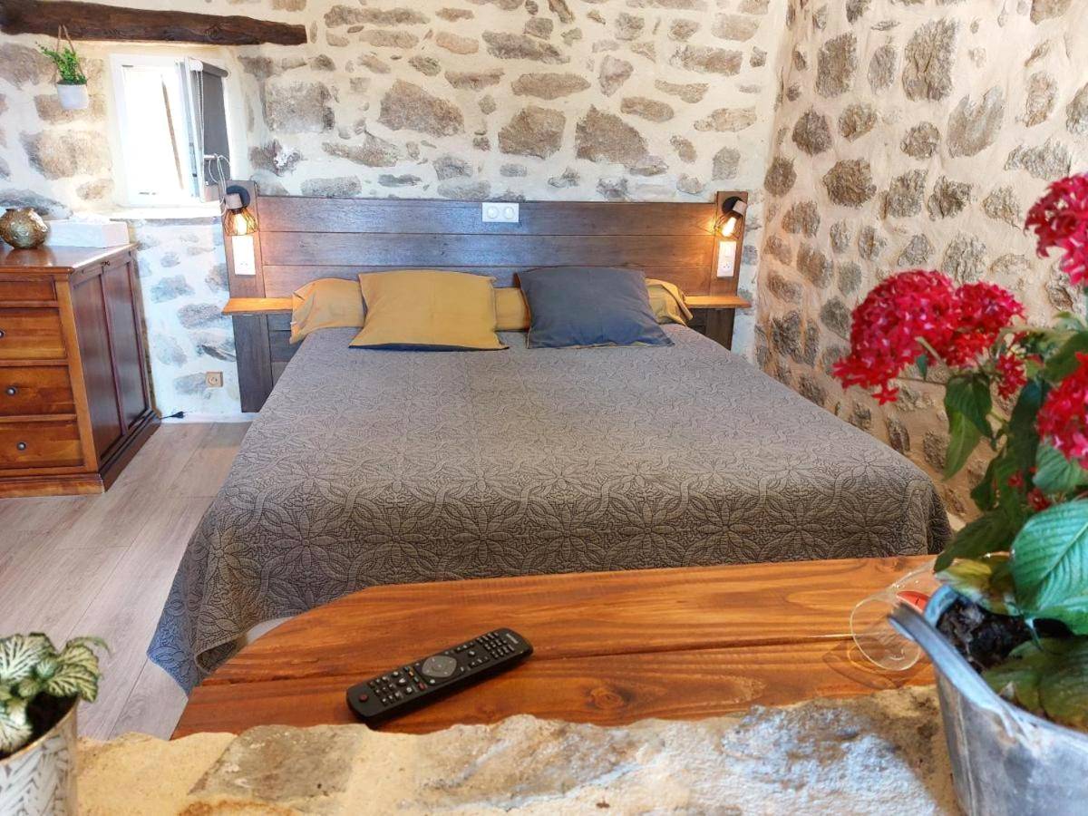 Lit double dans chambre aux murs de pierre - Chez Marinou