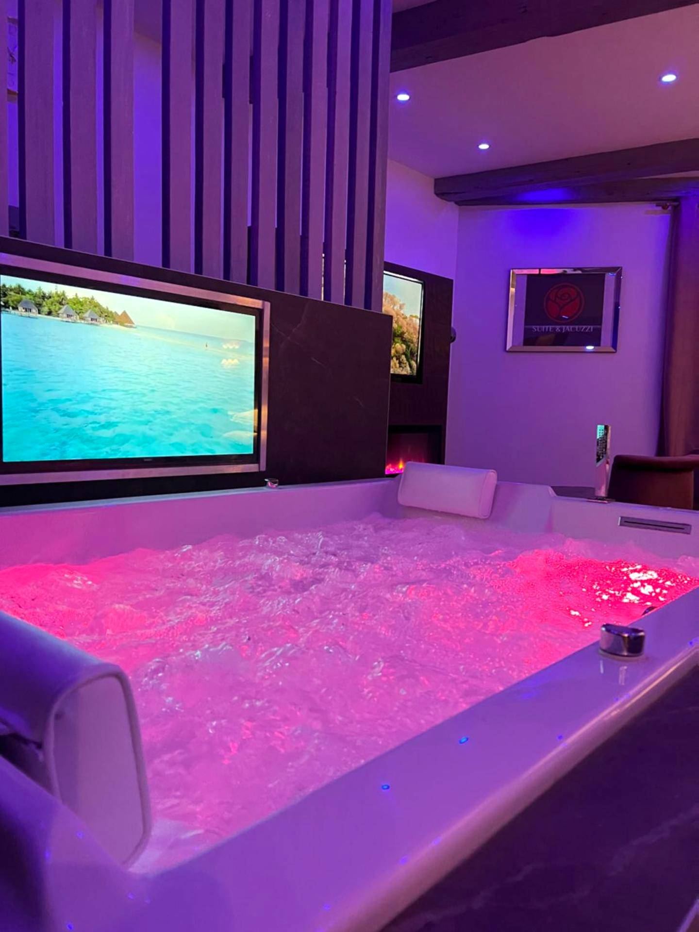 Jacuzzi privatif avec éclairage rose et TV - Love Room Givors - Chic & Jacuzzi