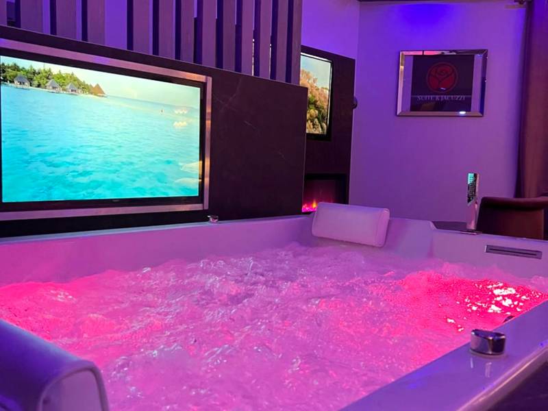 Jacuzzi privatif avec éclairage rose et TV - Love Room Givors - Chic & Jacuzzi
