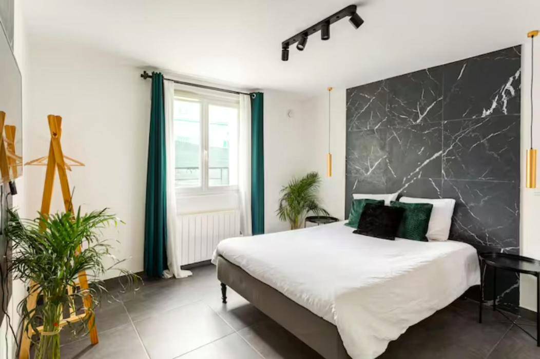 Chambre avec lit double et mur de marbre noir - LE CHILL Suite & SPA (Jacuzzi et Sauna privés)