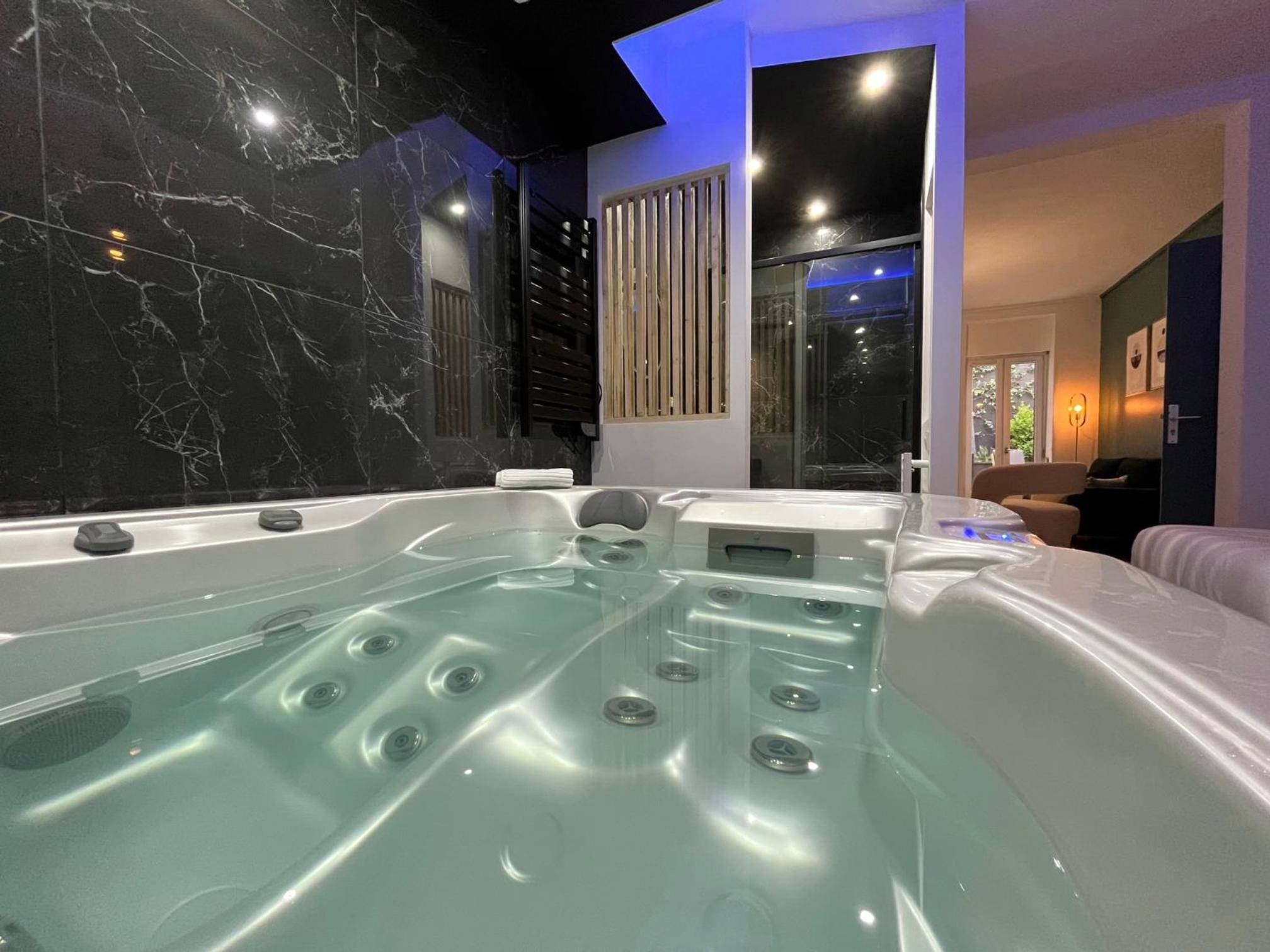 Jacuzzi avec éclairage LED et mur en marbre - CK Suite & Spa Reims
