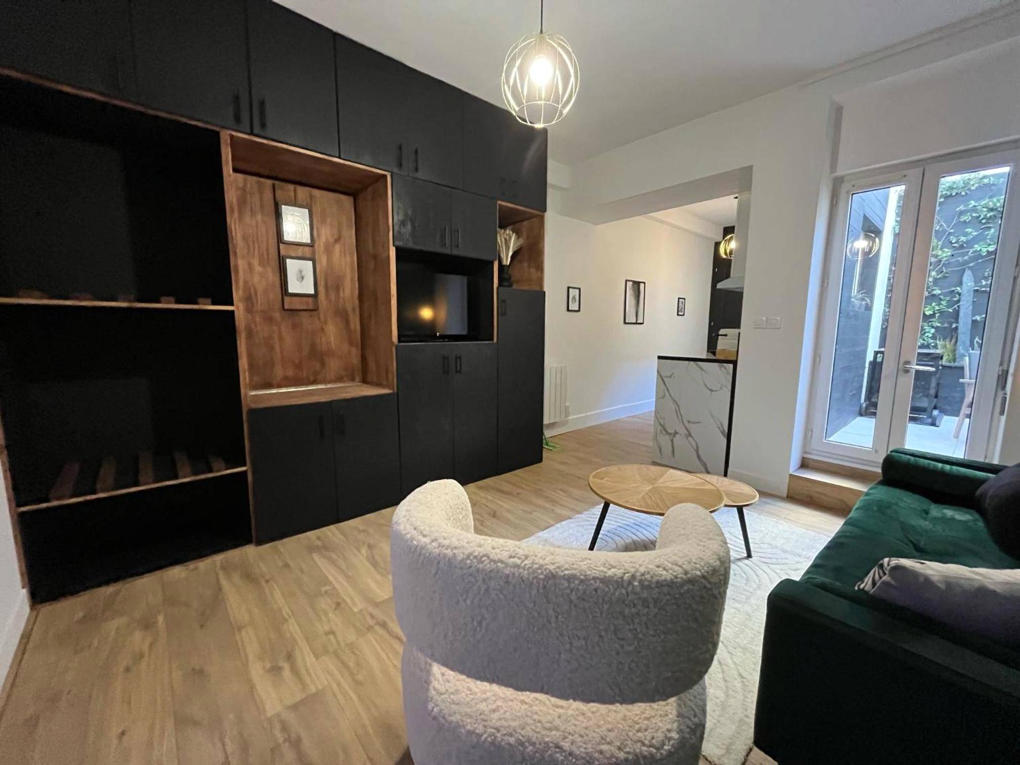 Salon avec canapé vert et fauteuil bouclée - CK Suite & Spa Reims
