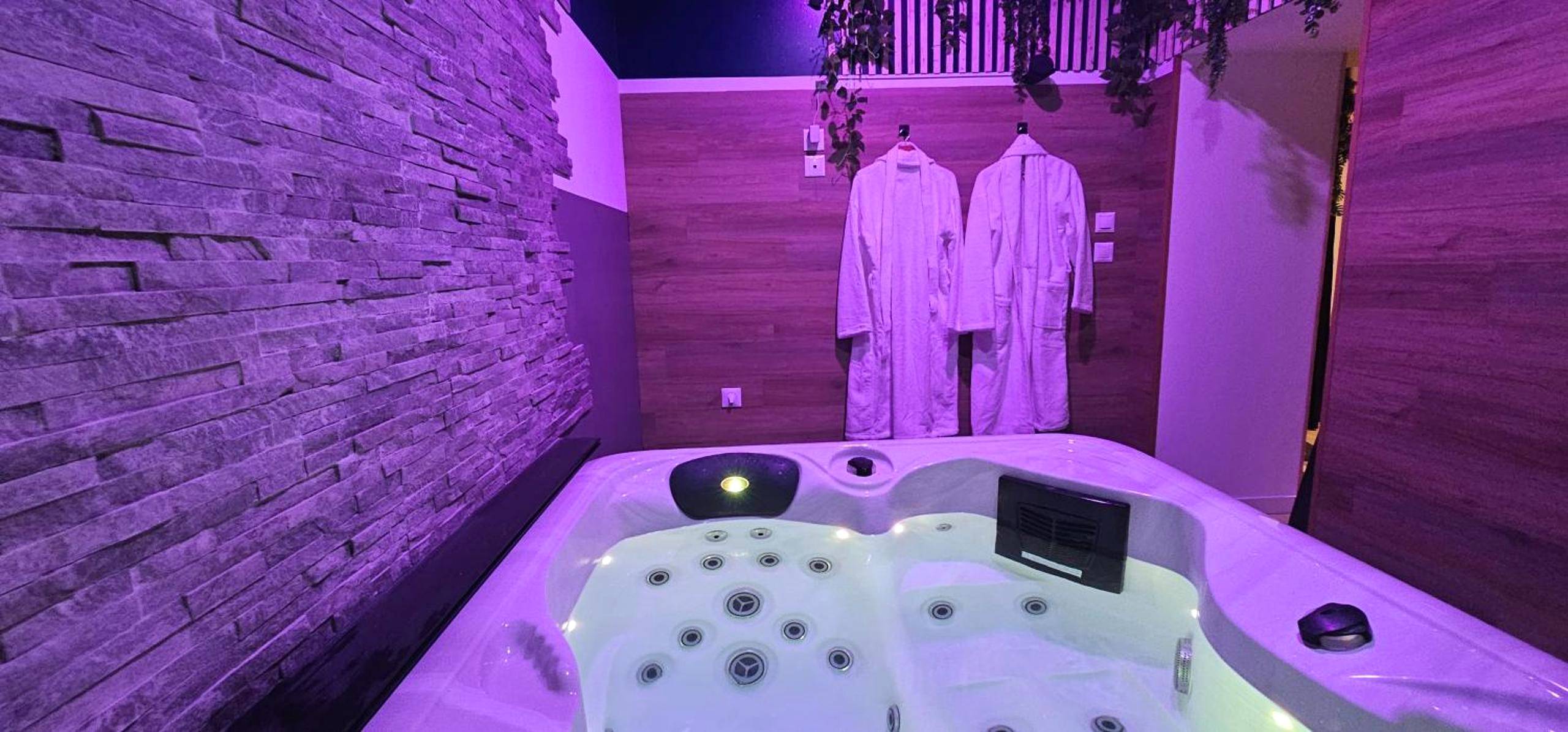 Espace spa avec peignoirs et mur de pierre - Le Clos Maldier - Gîte Les Ecureuils