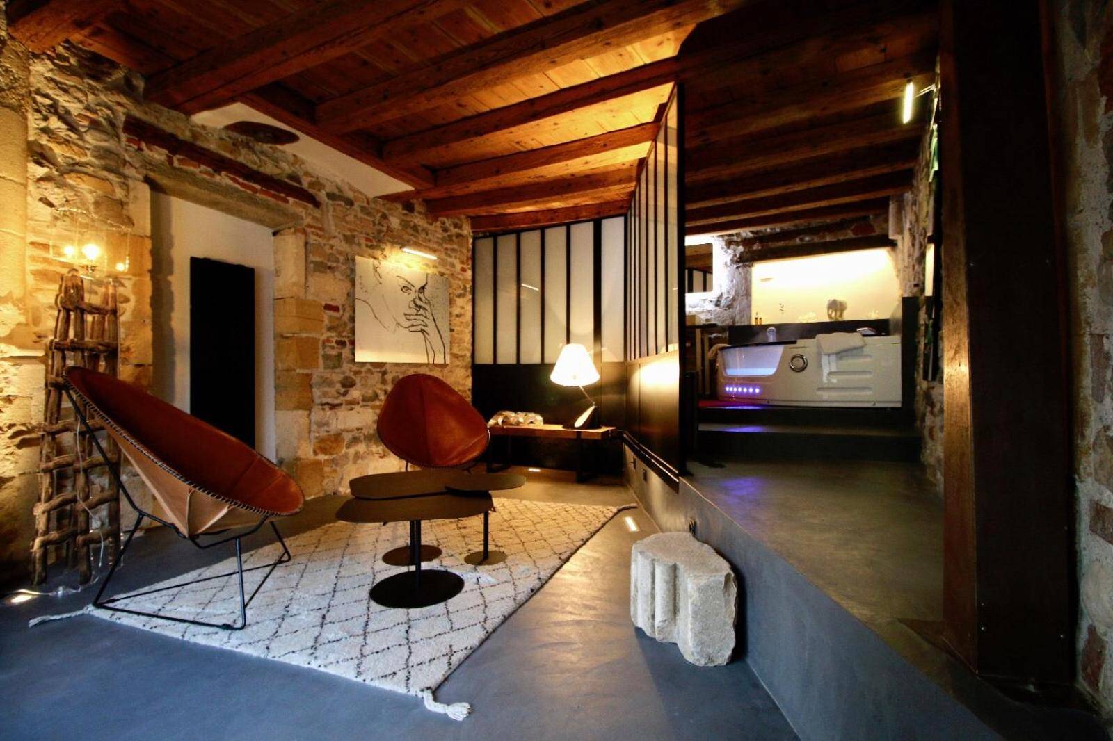 Espace détente avec murs en pierre et jacuzzi - Le Clos de Sainte Croix