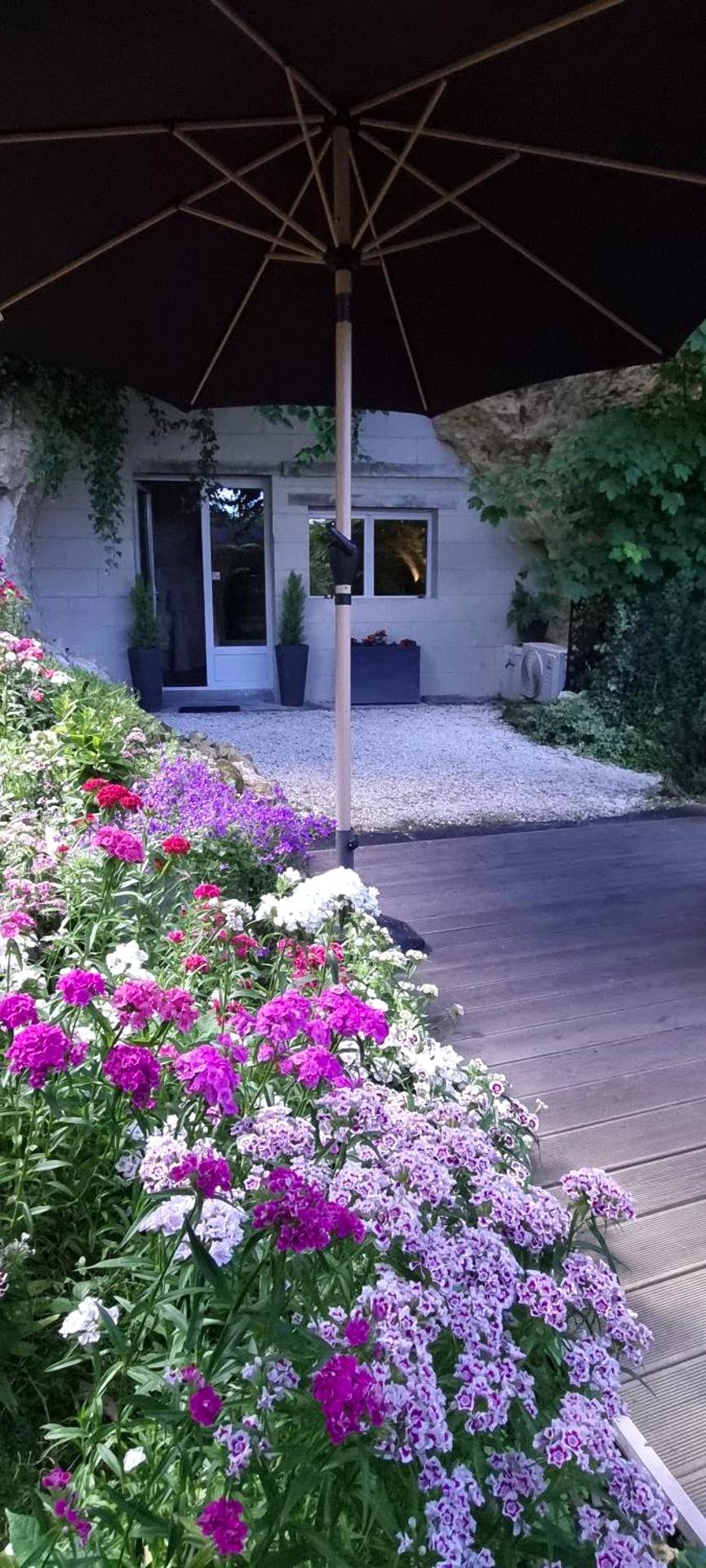 Terrasse fleurie avec parasol - Le clos des violettes