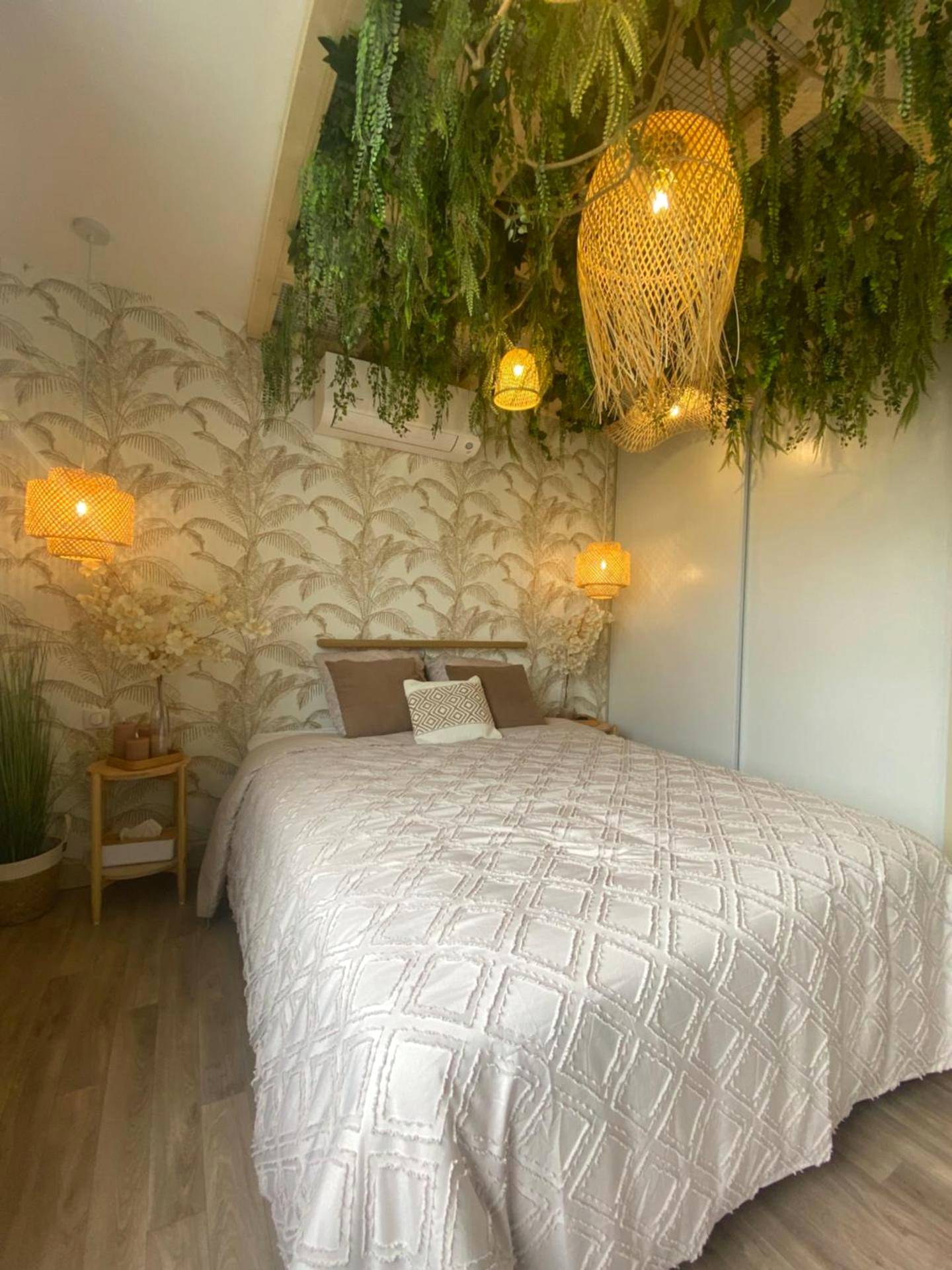 Lit double sous canopée végétale et luminaires - Le cocon du désir - Balnéo et haut de gamme