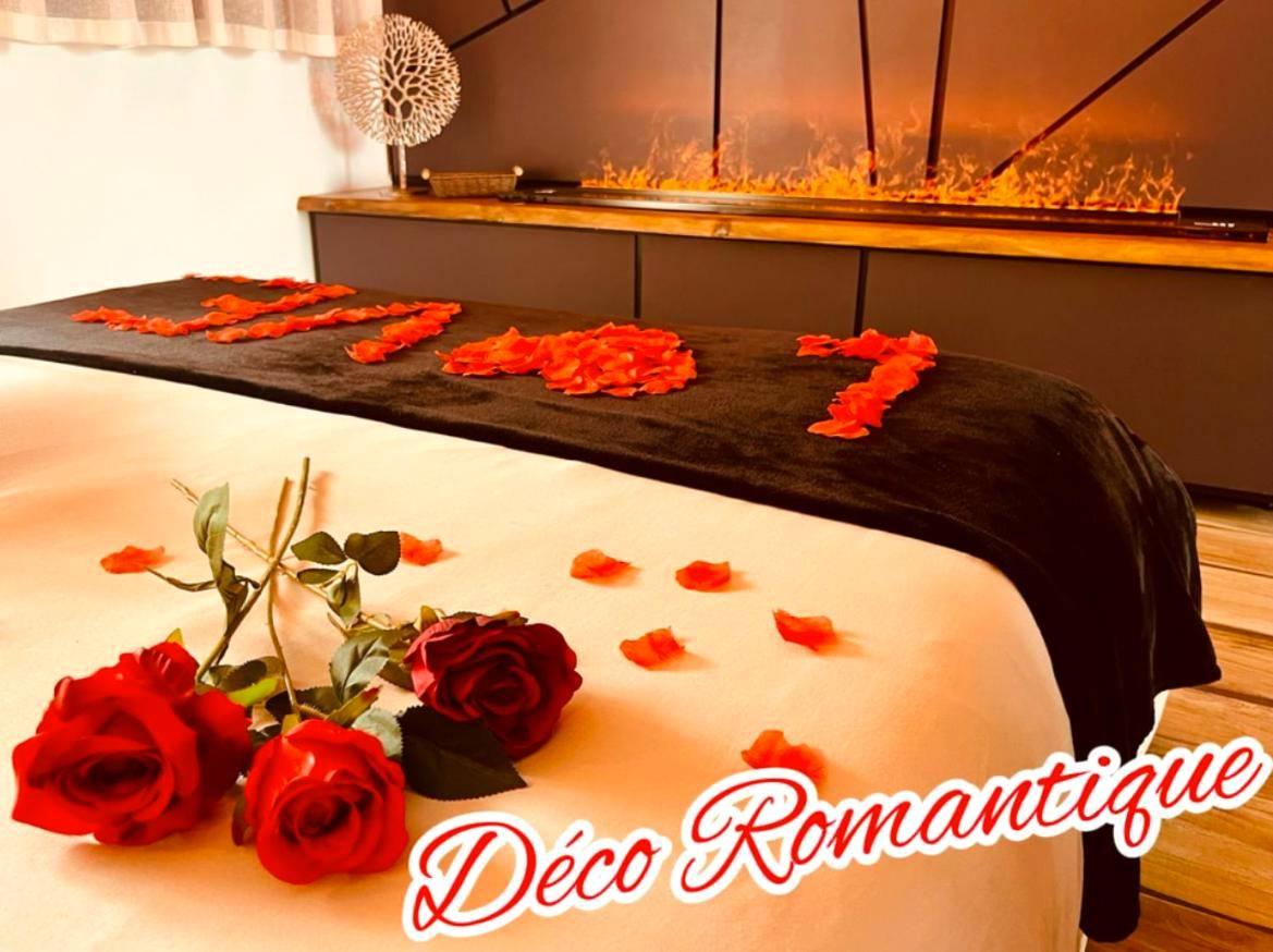 Lit avec pétales de rose et cheminée électrique - Love Room Le Barcarès - Cocon détente pour 2 avec hammam et jacuzzi...