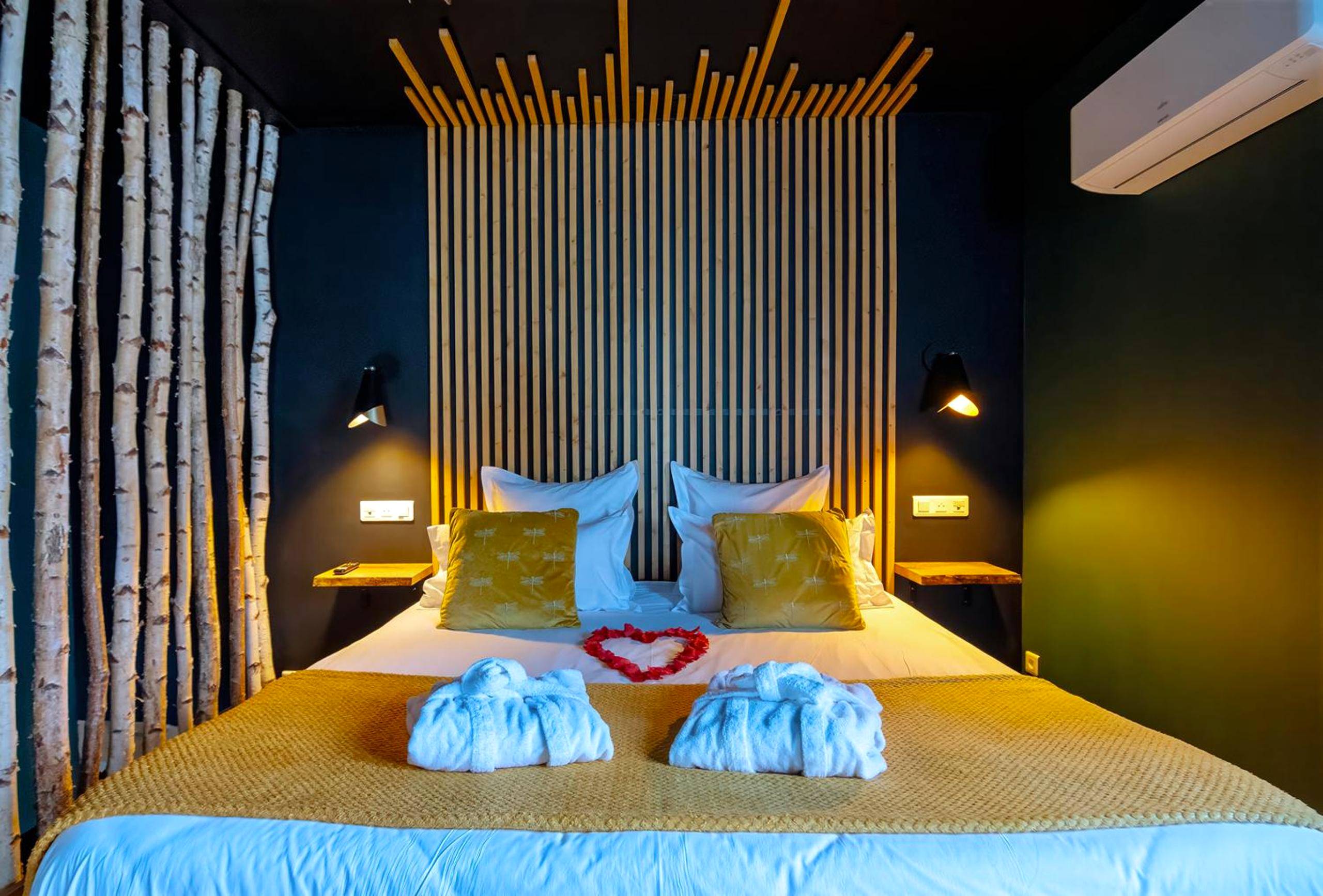 Lit préparé avec cœur en pétales et peignoirs - Le Cocon du Domaine des Ecus d'Or