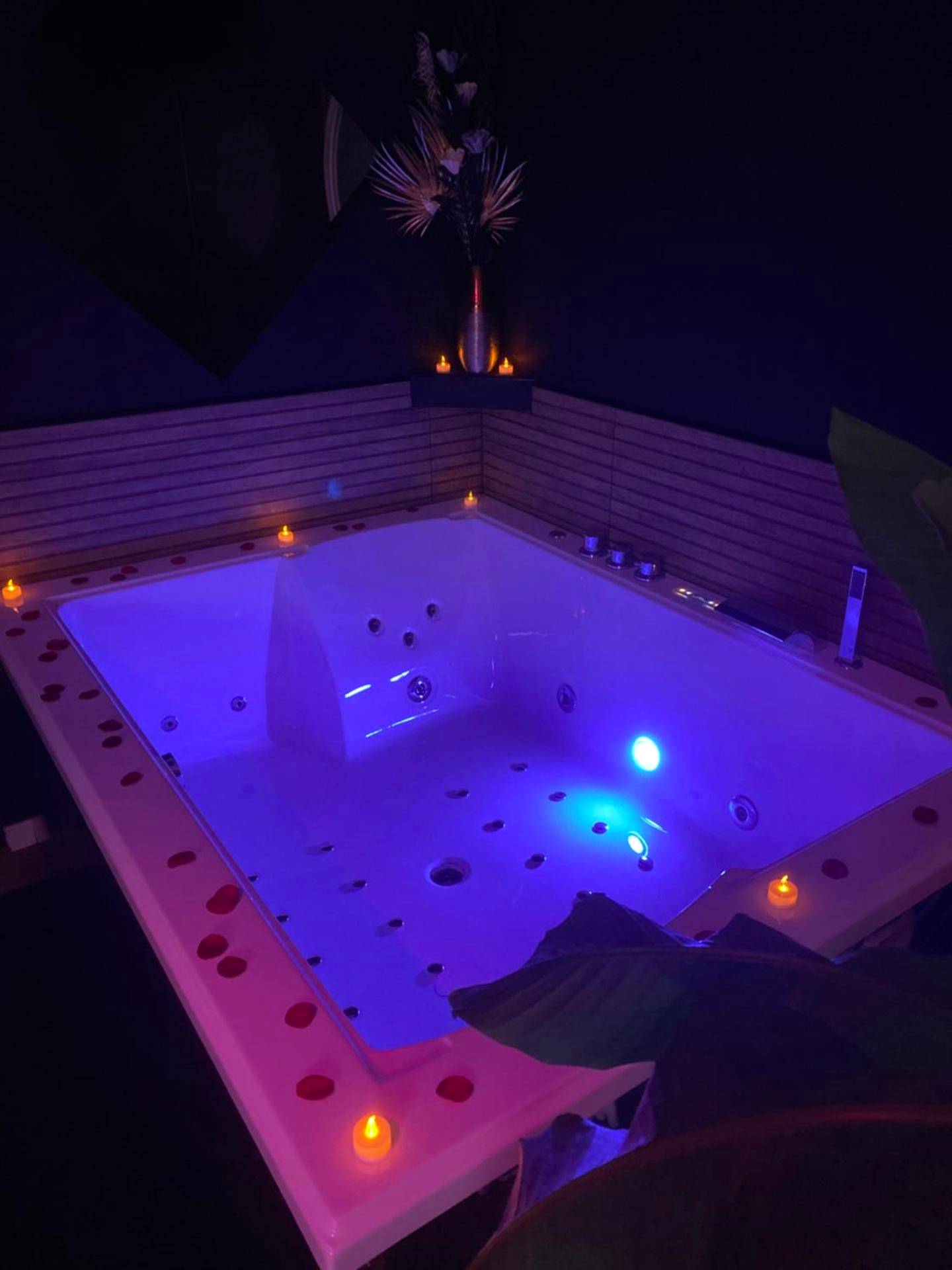 Jacuzzi privatif avec éclairage bleu et bougies - Love Room Port - sur - Saône - Cocon doré