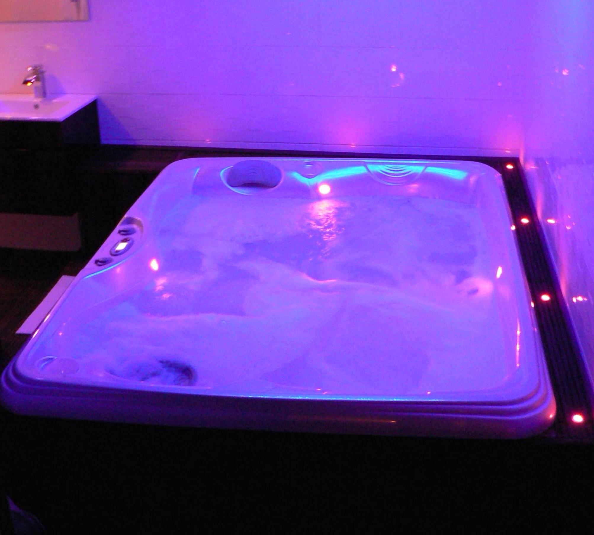 Jacuzzi privatif avec éclairage néon violet - Love room proche Rennes Le Cocon Enchanteur