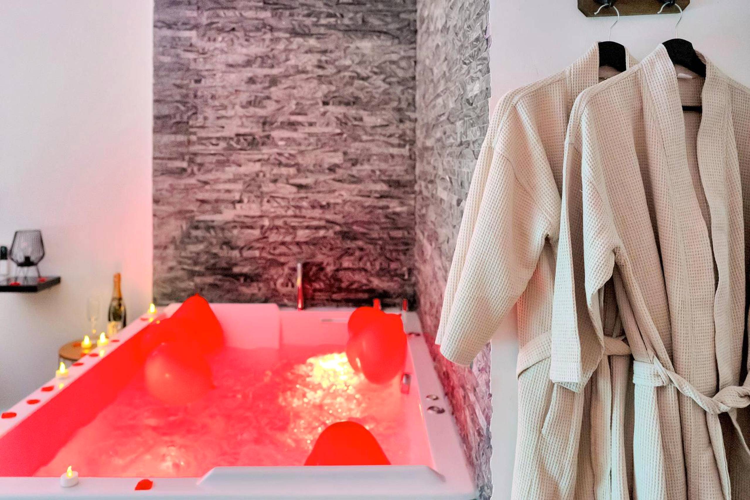 Peignoirs blancs suspendus près du jacuzzi - LE COCON - Jacuzzi & Sauna privés By SweetDreams