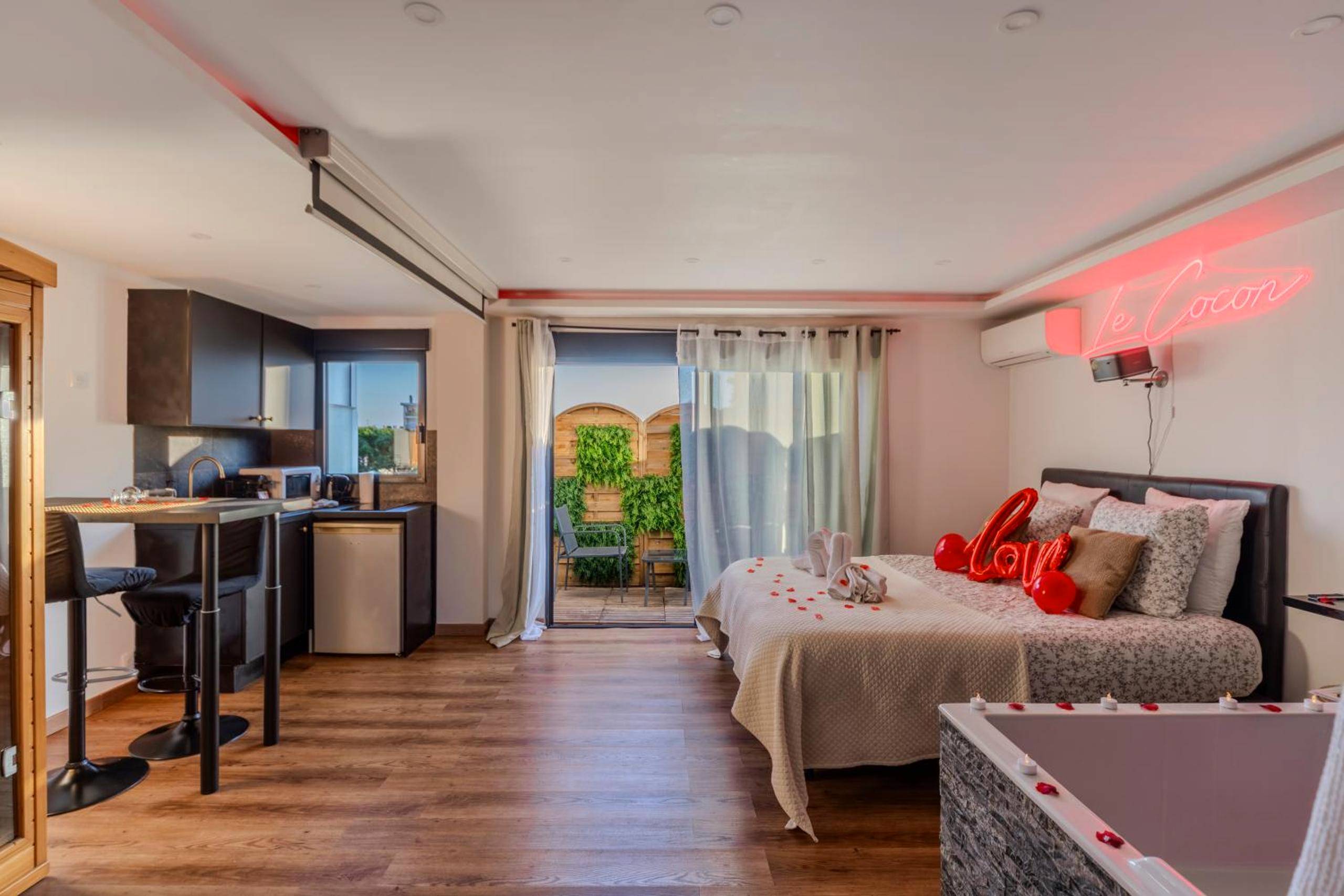 Vue d'ensemble avec coin cuisine et terrasse - LE COCON - Jacuzzi & Sauna privés By SweetDreams